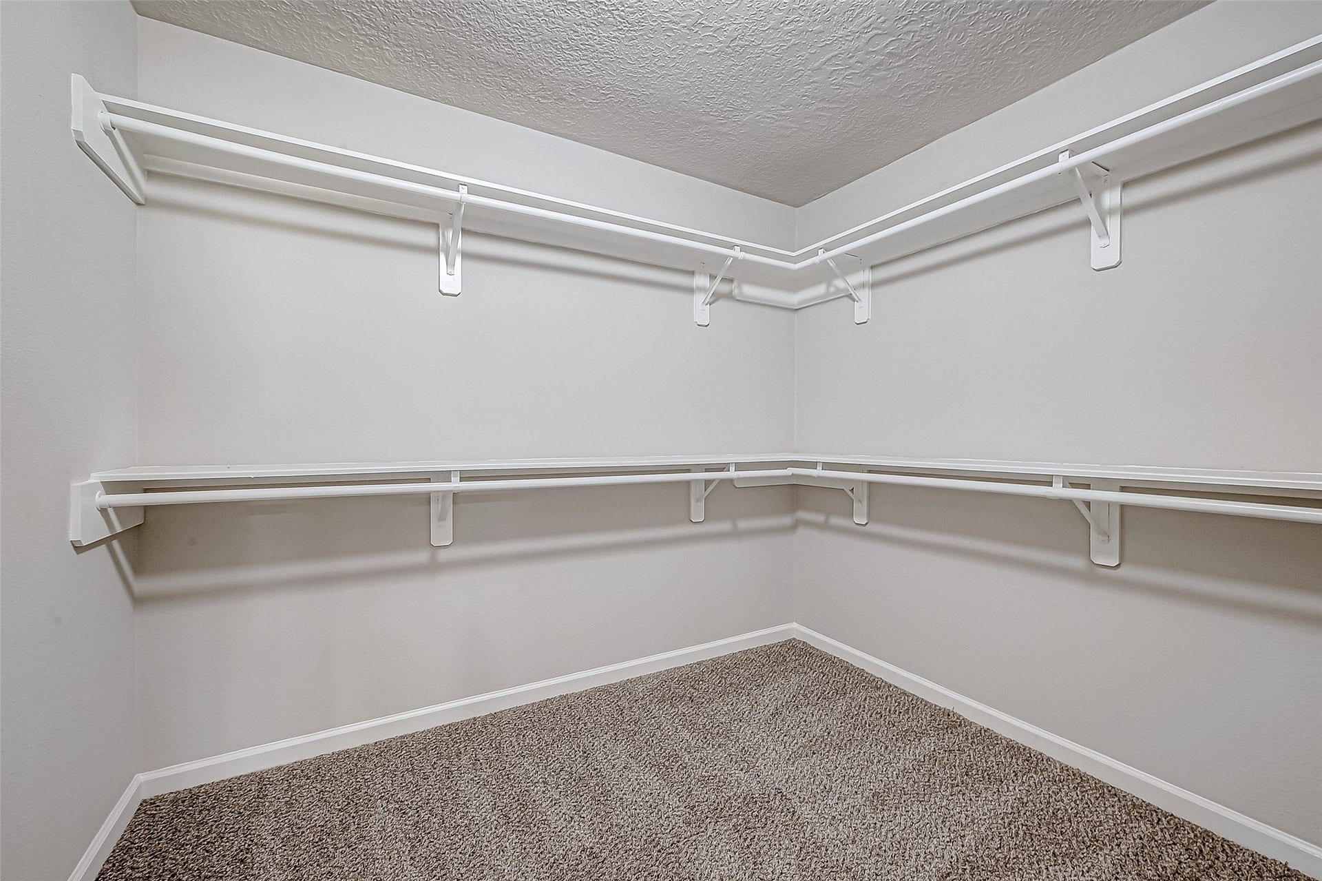3102 Glenn Lakes Lane, Missouri City, TX 77459 Walk-in closet featuring dual-level white shelving perfect for organizing clothing and accessories.