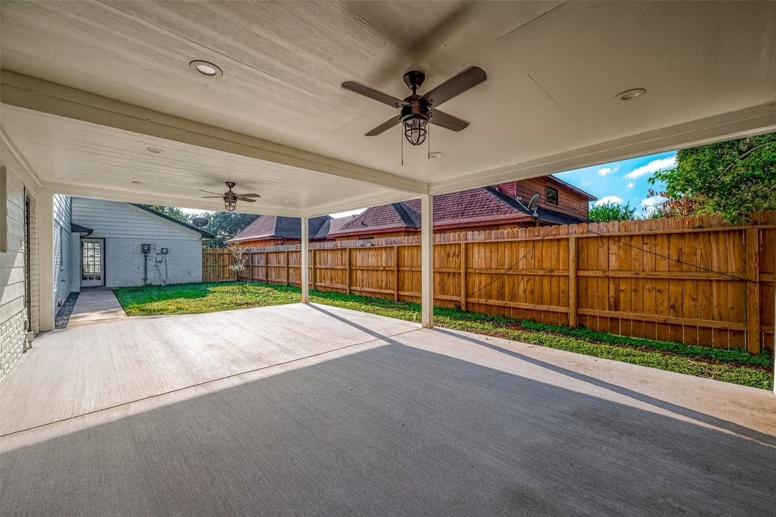 3102 Glenn Lakes Lane, Missouri City, TX 77459 A covered patio with ceiling fans offers an ideal setting for outdoor gatherings, while the fenced yard ensures privacy and security.