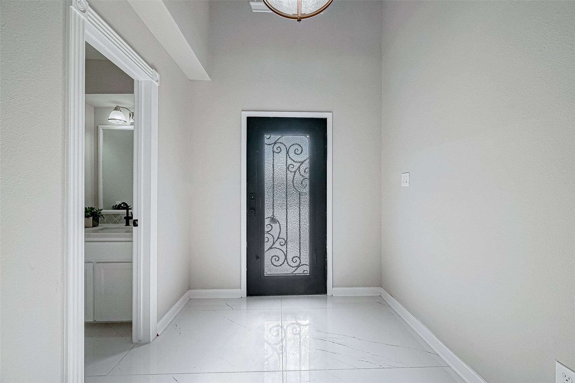 3102 Glenn Lakes Lane, Missouri City, TX 77459 Bright, modern entryway featuring a decorative black door and white tile flooring.