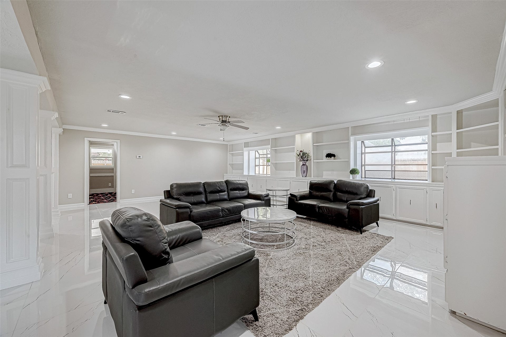 3102 Glenn Lakes Lane, Missouri City, TX 77459 The living area includes a comfortable black leather sofa set, a central coffee table, and a ceiling fan.
