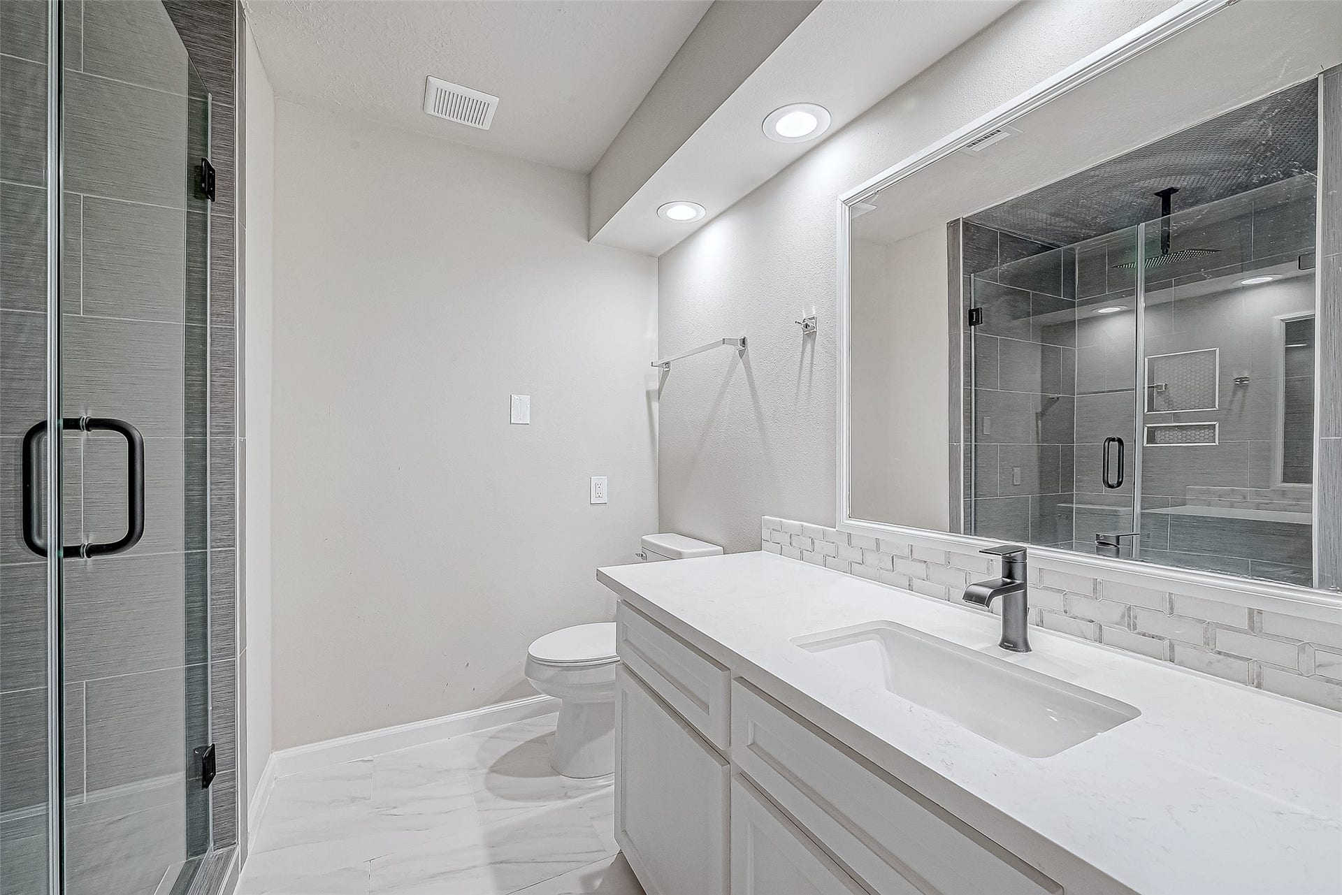 3102 Glenn Lakes Lane, Missouri City, TX 77459 This bathroom features a modern design with a vanity with a contemporary faucet, large mirror and bright overhead lighting.