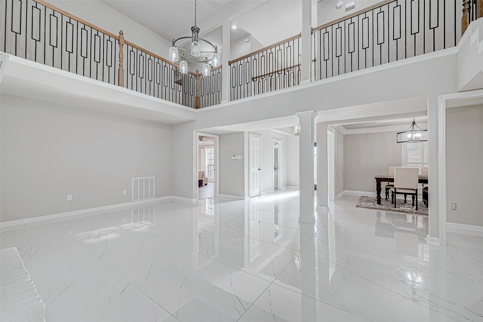 3102 Glenn Lakes Lane, Missouri City, TX 77459 A bright open floor plan with high ceilings, elegant railing, and glossy white tile floors.