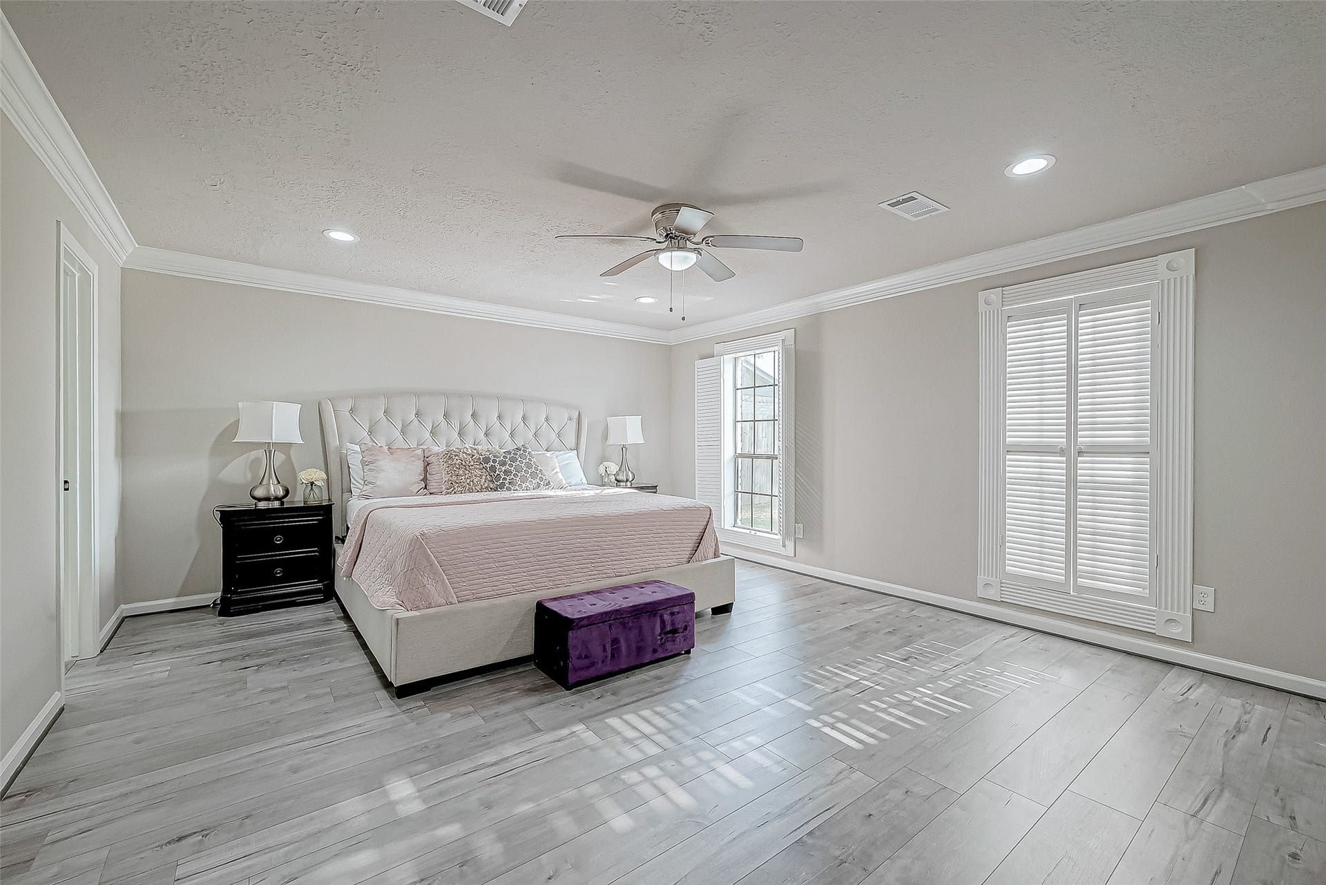 3102 Glenn Lakes Lane, Missouri City, TX 77459 Primary bedroom features elegant hardwood floors, a cozy bed with a tufted headboard.