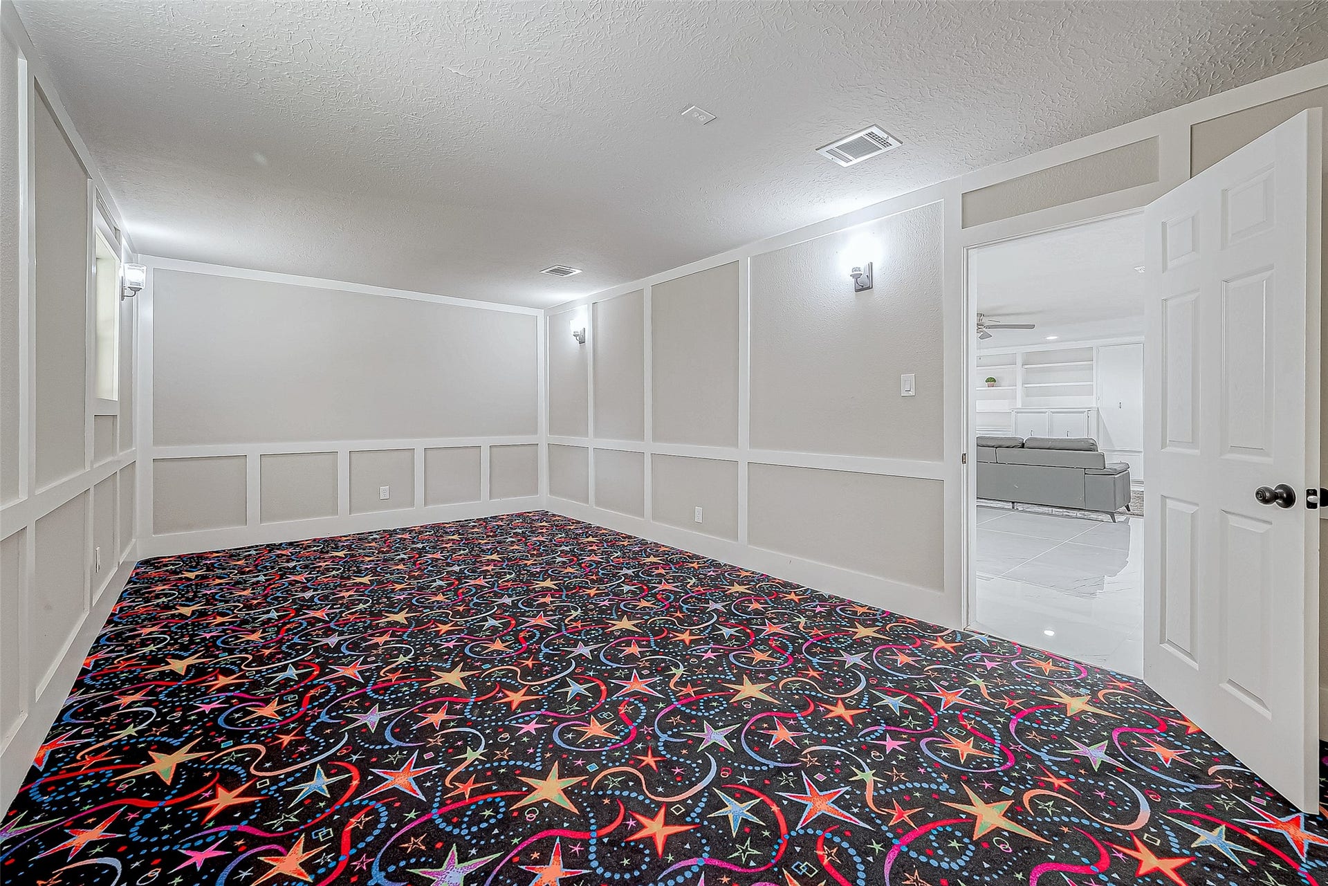 3102 Glenn Lakes Lane, Missouri City, TX 77459 The versatile room features a vibrant, star-patterned carpet. An open doorway connects to the living area, perfect for a home theater or playroom.