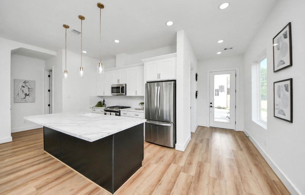 2428 Harrington Street, Houston, TX 77026 Spacious kitchen featuring a large island, perfect for meal prep, entertaining, and everyday living. Refrigerator is included with the home. Photos are from a separate model home, so furniture and decor may vary.