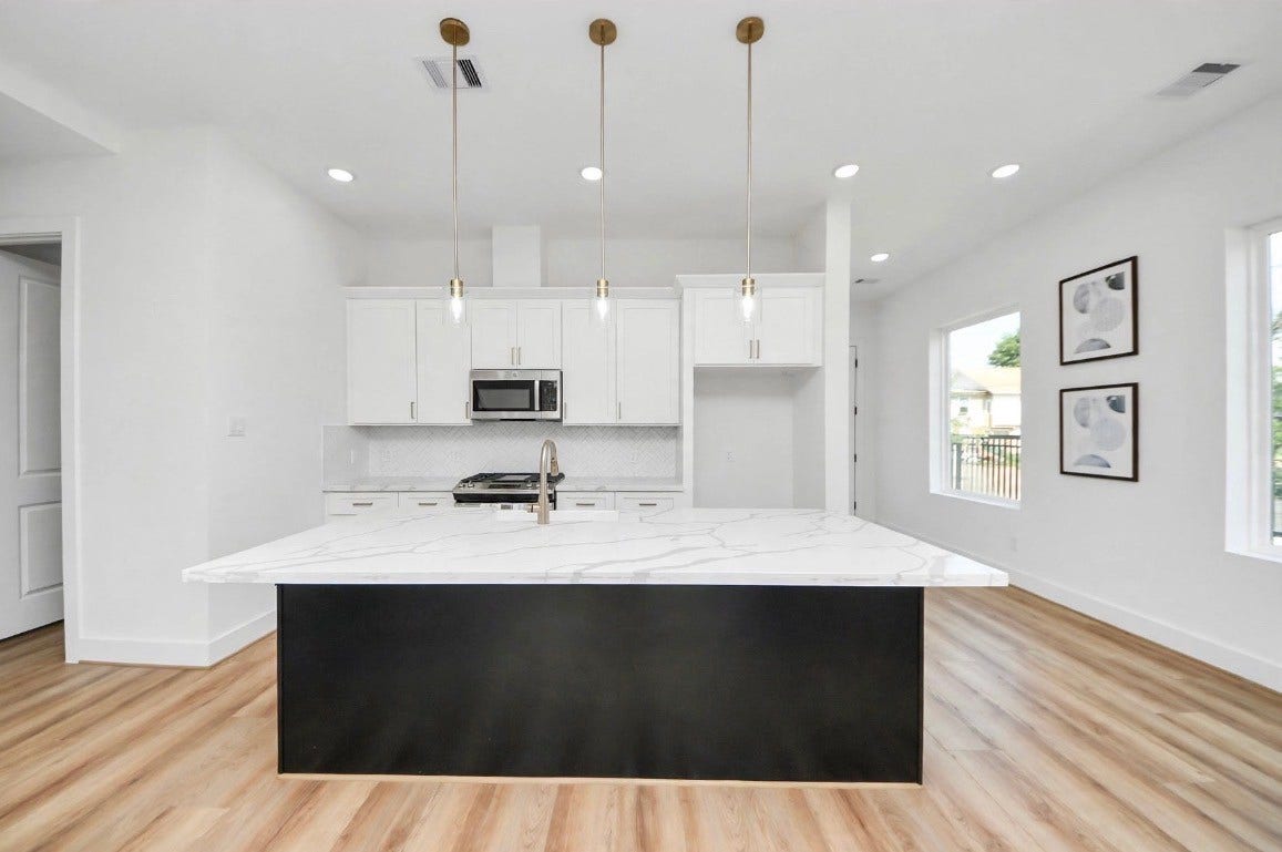 2428 Harrington Street, Houston, TX 77026 Spacious kitchen featuring a large island, perfect for meal prep, entertaining, and everyday living. Refrigerator is included with the home. Photos are from a separate model home, so furniture and decor may vary.