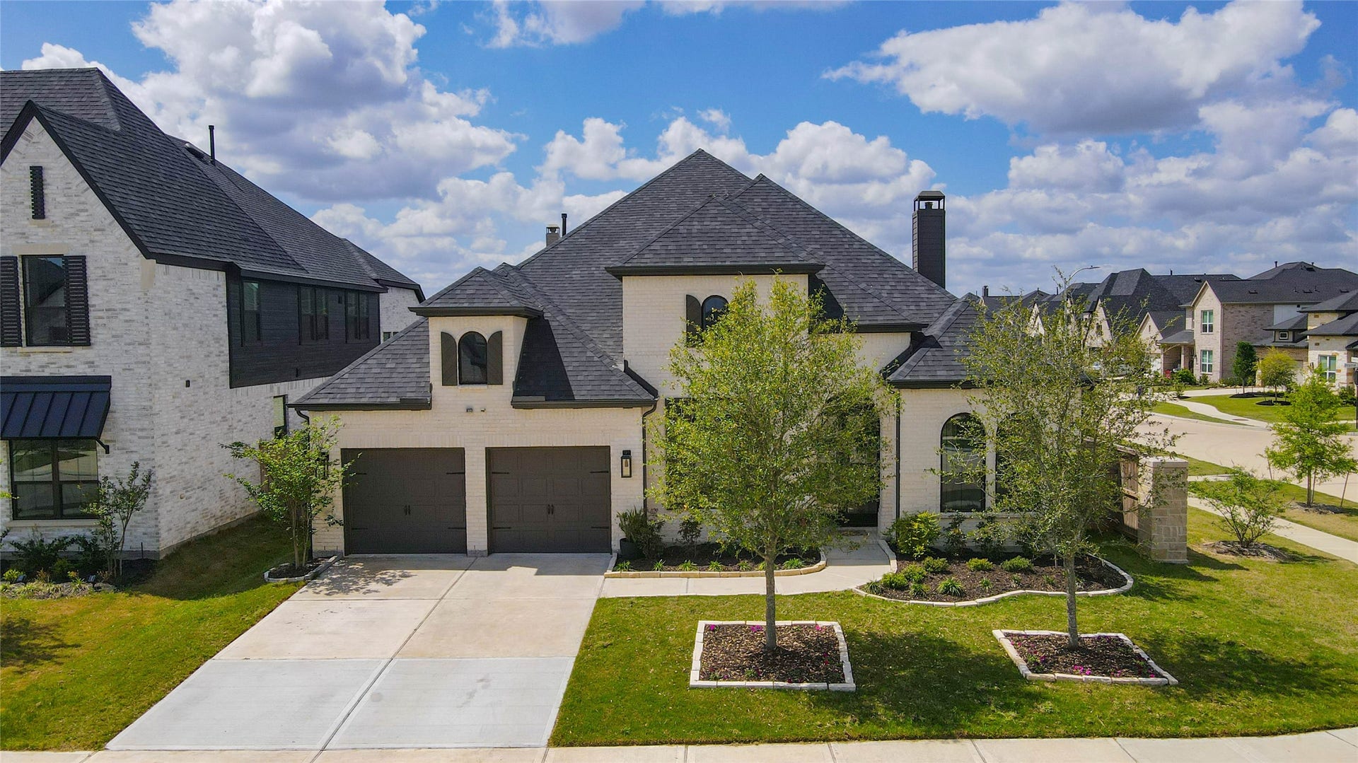 4510 Windmill Landing Lane, Fulshear, TX 77441 1 story Highland Homes with a dark shingle roof and a two-car garage. The front yard is well-maintained, featuring trees and landscaped flower beds. It's located in Cross Creek West neighborhood with similar-style homes.