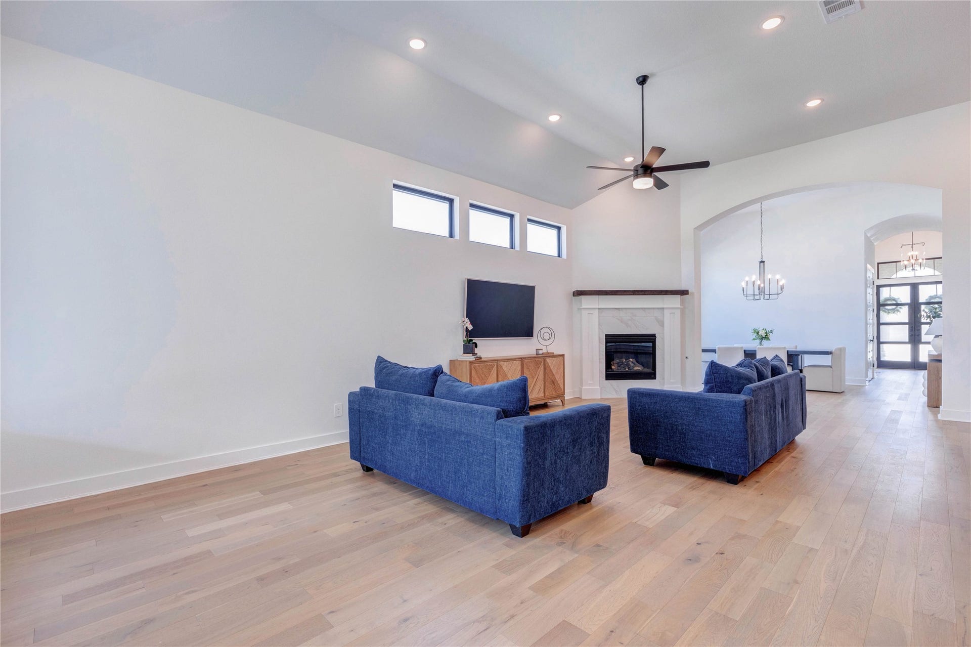 4510 Windmill Landing Lane, Fulshear, TX 77441 Open and contemporary living area featuring a sleek fireplace as the main focal point. The design emphasizes a bright, airy space with clean lines and modern aesthetics, making the fireplace a stunning centerpiece.