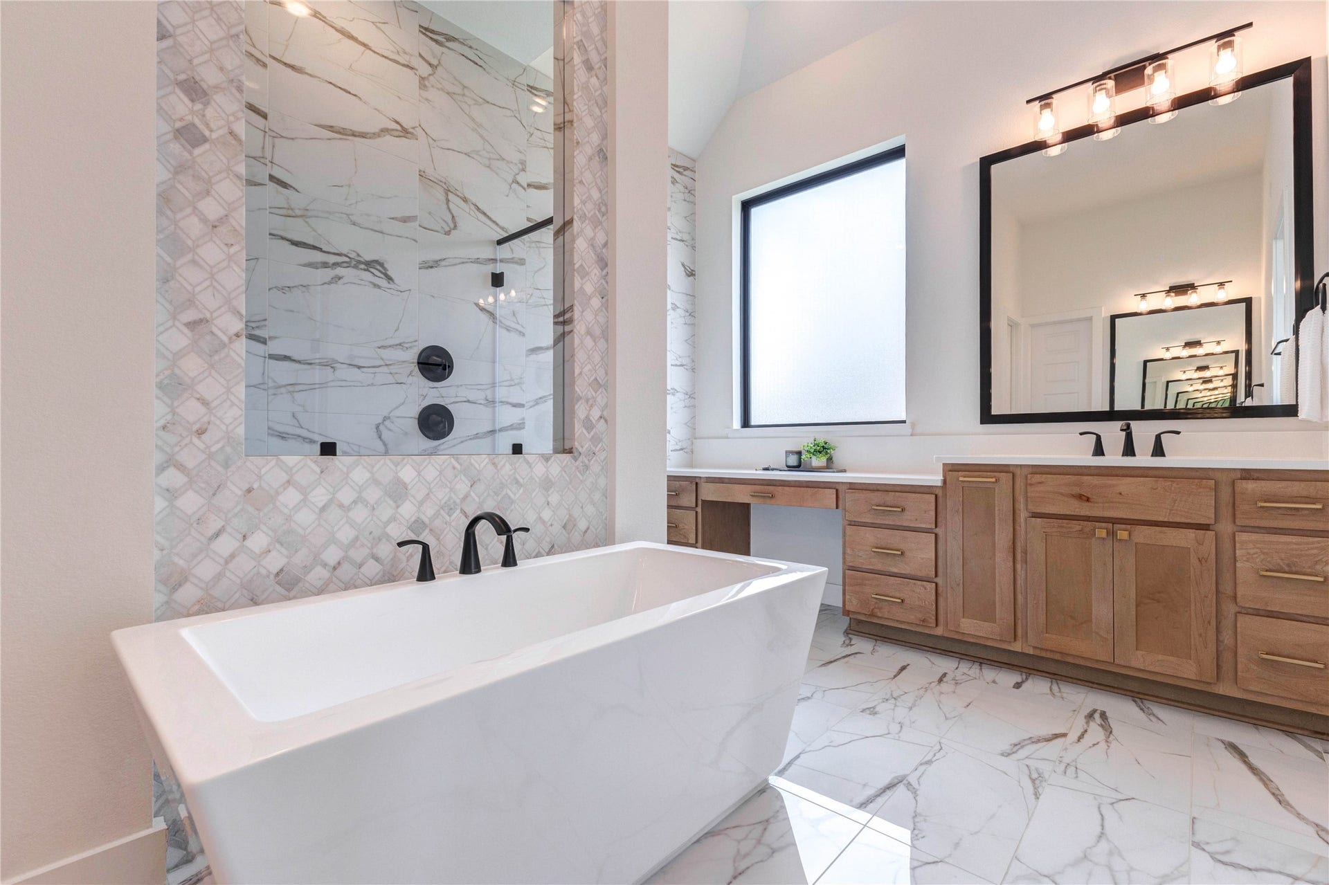 4510 Windmill Landing Lane, Fulshear, TX 77441 This bathroom features a modern freestanding tub, elegant marble-patterned tiles, and a spacious glass-enclosed shower. It also includes a sleek vanity with ample natural light from a large window.