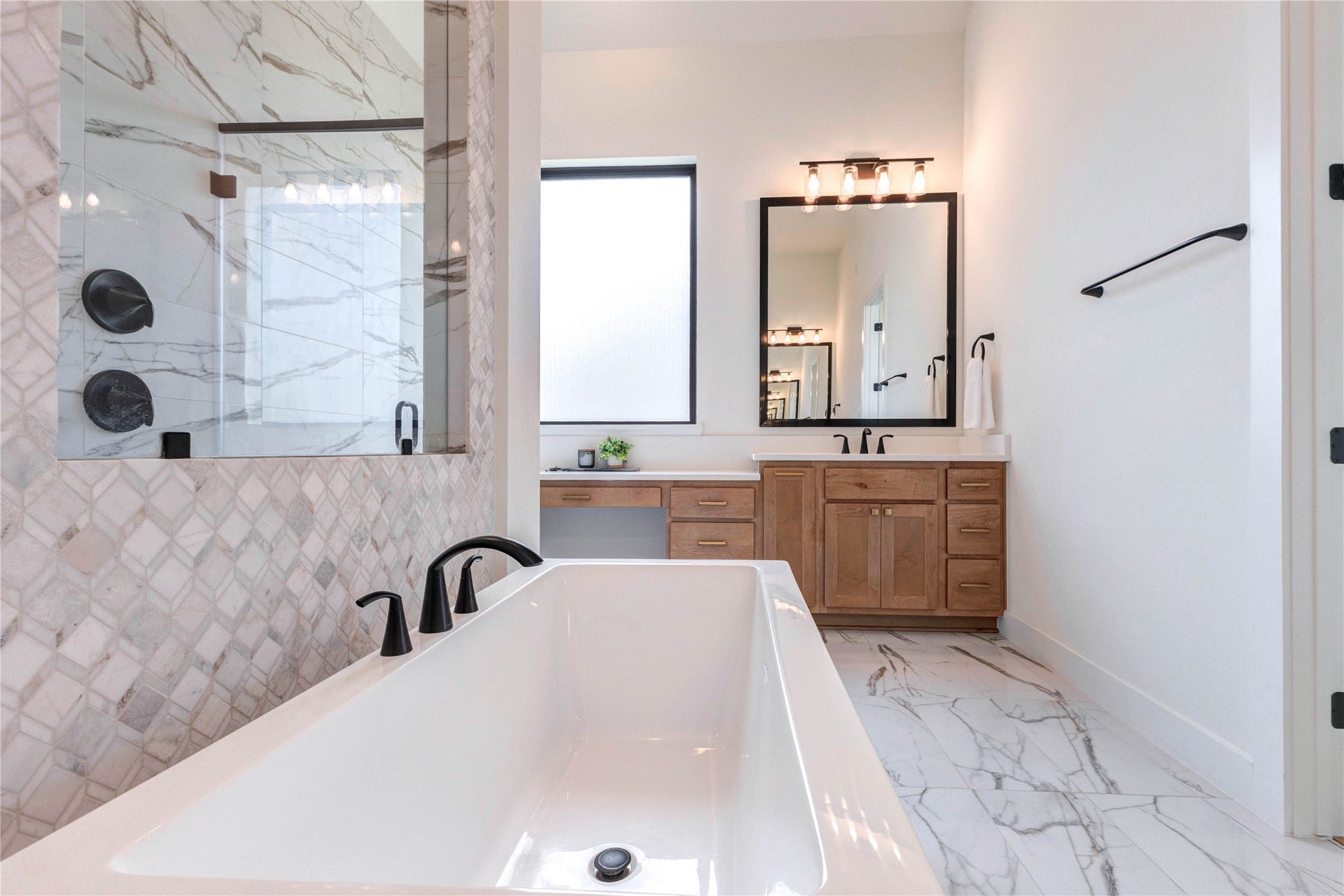 4510 Windmill Landing Lane, Fulshear, TX 77441 This modern bathroom features a luxurious freestanding tub, a spacious walk-in shower with elegant tilework, and a double vanity with ample storage. It boasts a sleek, contemporary design with stylish fixtures and abundant natural light.