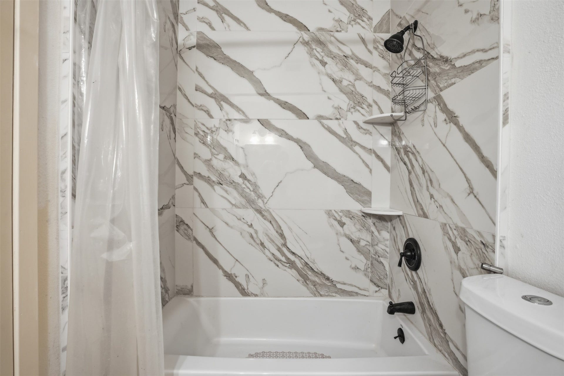 Beautiful tub/shower combination with built in corner shelves.