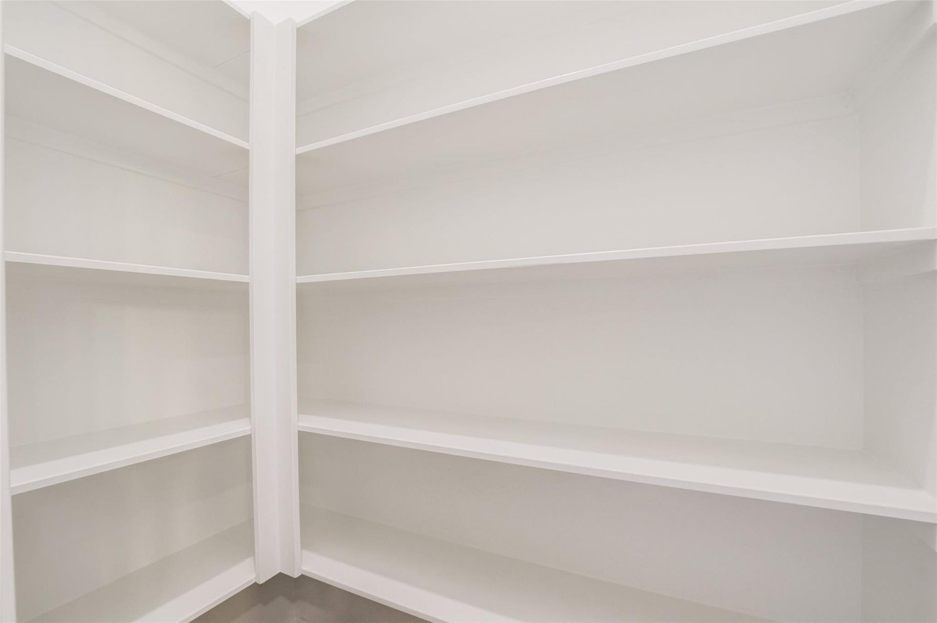 Walk in pantry with ample shelving for storage. Perfect for organizing groceries and kitchen essentials.
