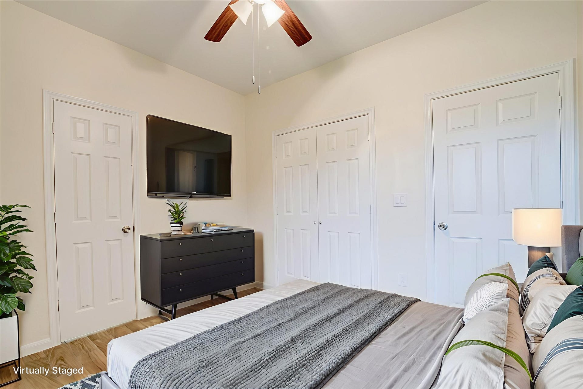 Secondary bedroom features tile floors, a ceiling fan, and neutral walls.
