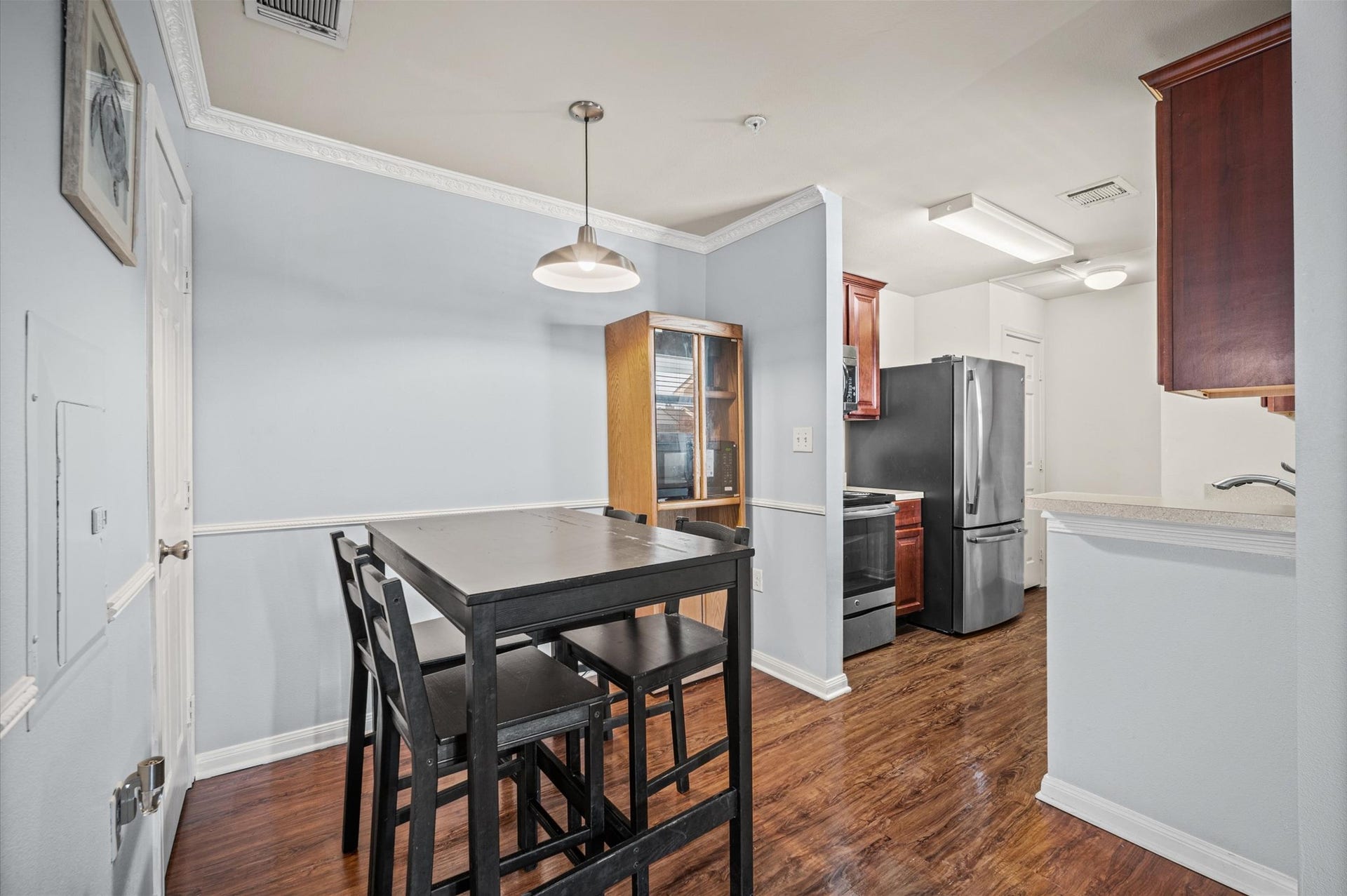 7600 Emmett F Lowry Expressway, #416, Texas City, TX 77591 Charming kitchen and dining area featuring modern appliances, sleek wood cabinetry, and warm hardwood floors, perfect for cozy meals and gatherings.