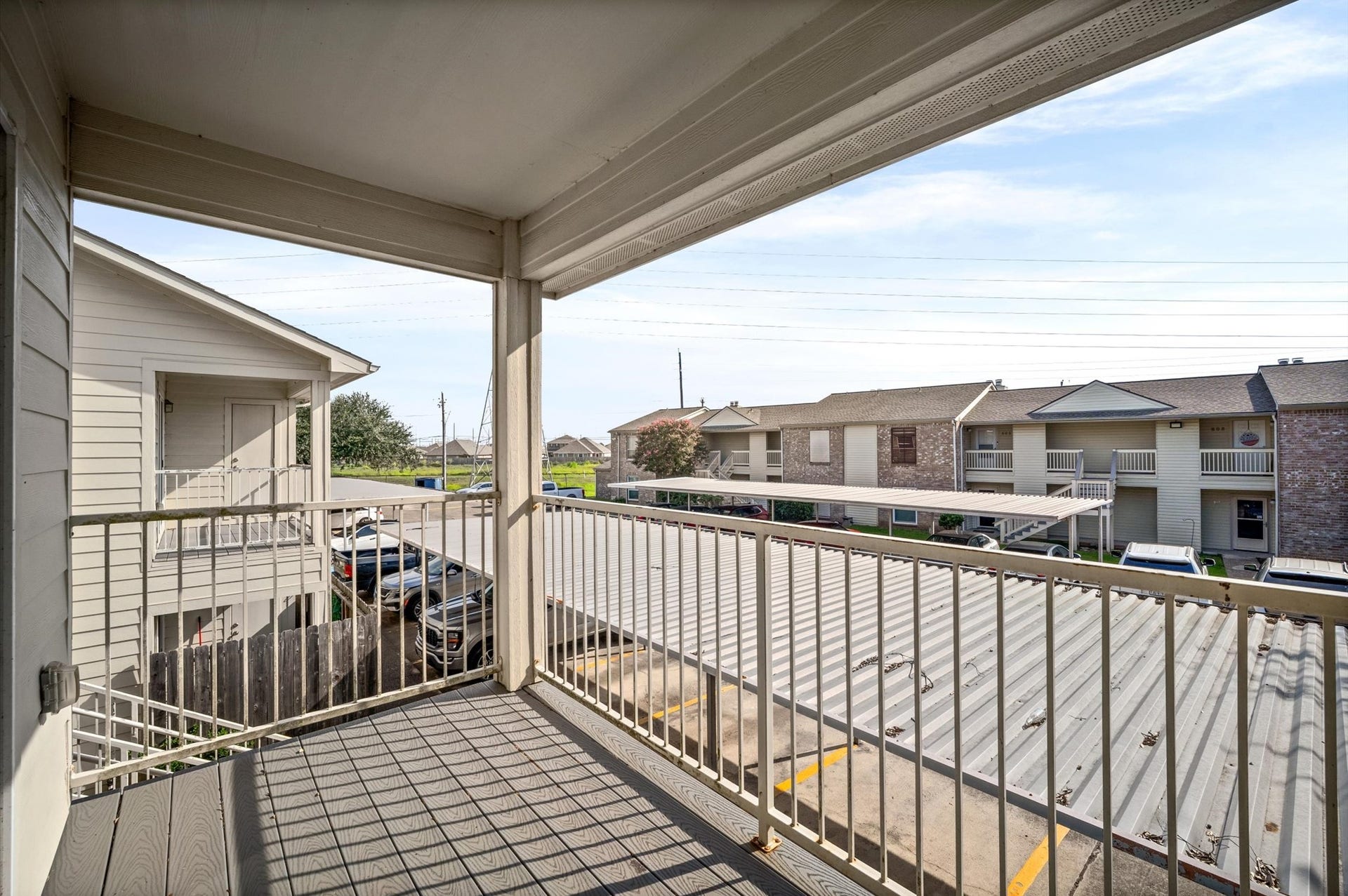 7600 Emmett F Lowry Expressway, #416, Texas City, TX 77591 Spacious covered balcony offering a view of the surrounding residential area, perfect for relaxation and enjoying the outdoors.
