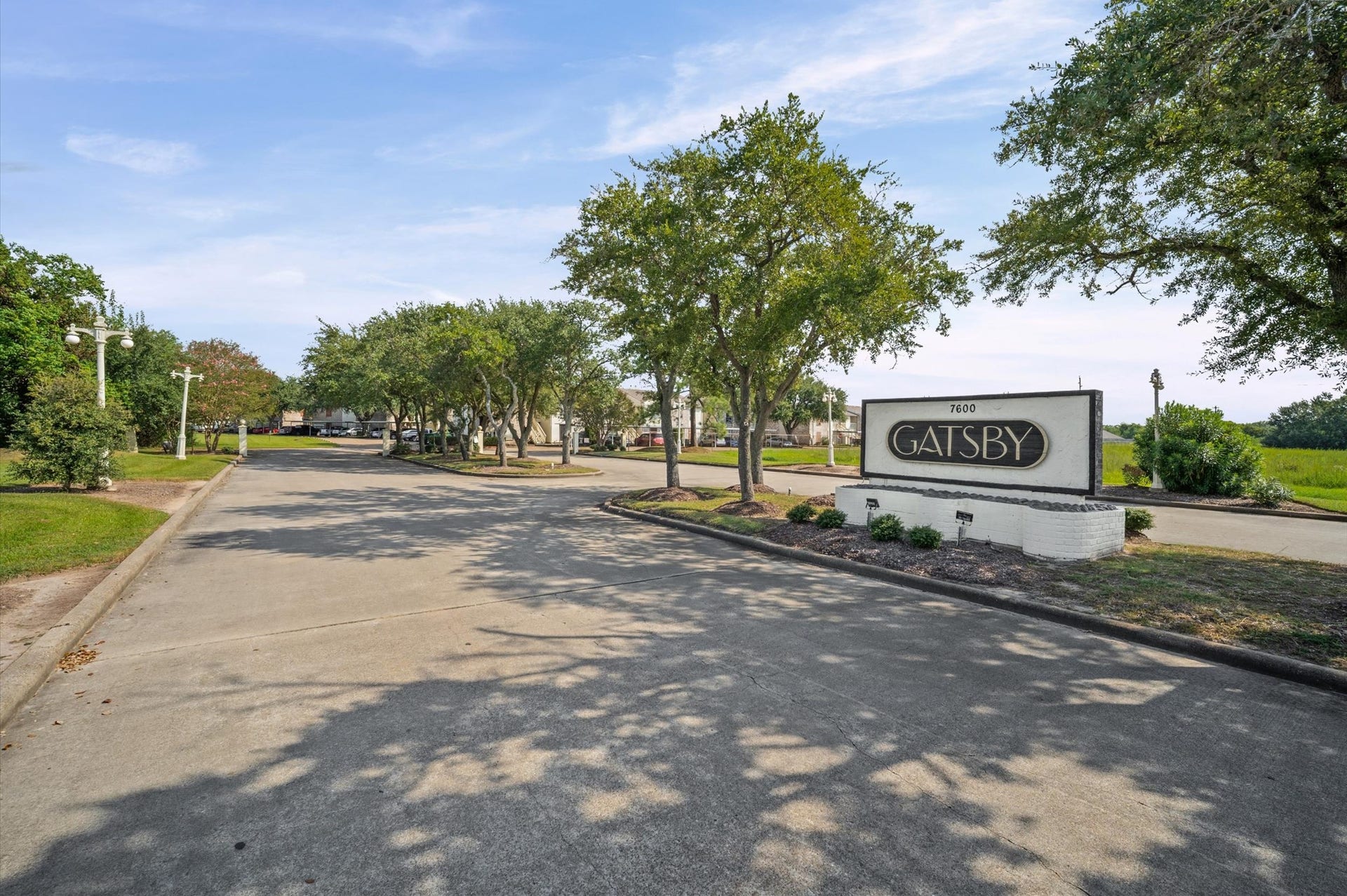7600 Emmett F Lowry Expressway, #416, Texas City, TX 77591 Charming entrance to the Gatsby community, lined with mature trees and well-maintained landscaping, offering a welcoming and serene setting.