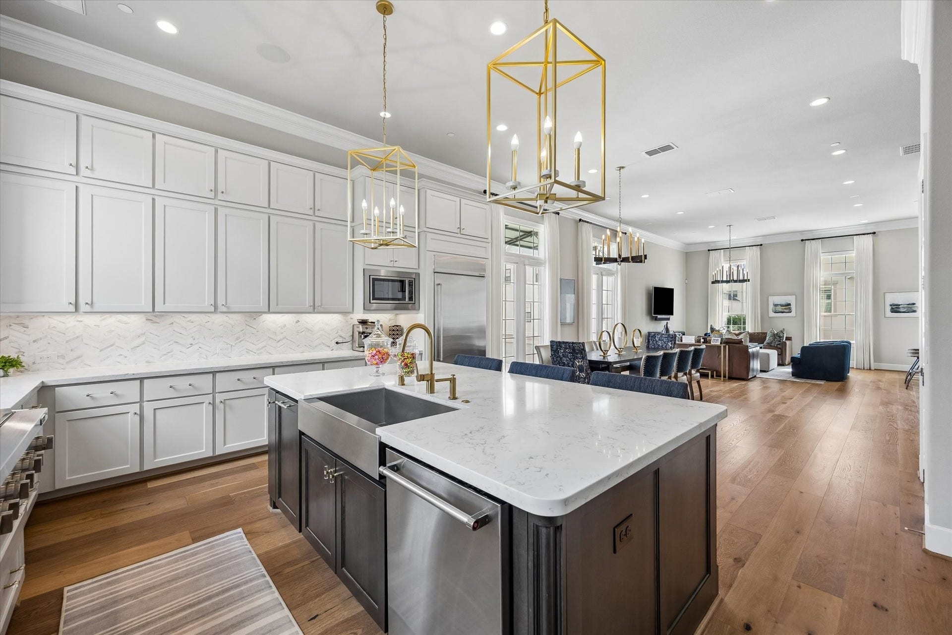 The expansive kitchen offers an abundance of prep space and storage to keep everything tucked away and organized. Note the under cabinet lighting and tasteful pendant lights.