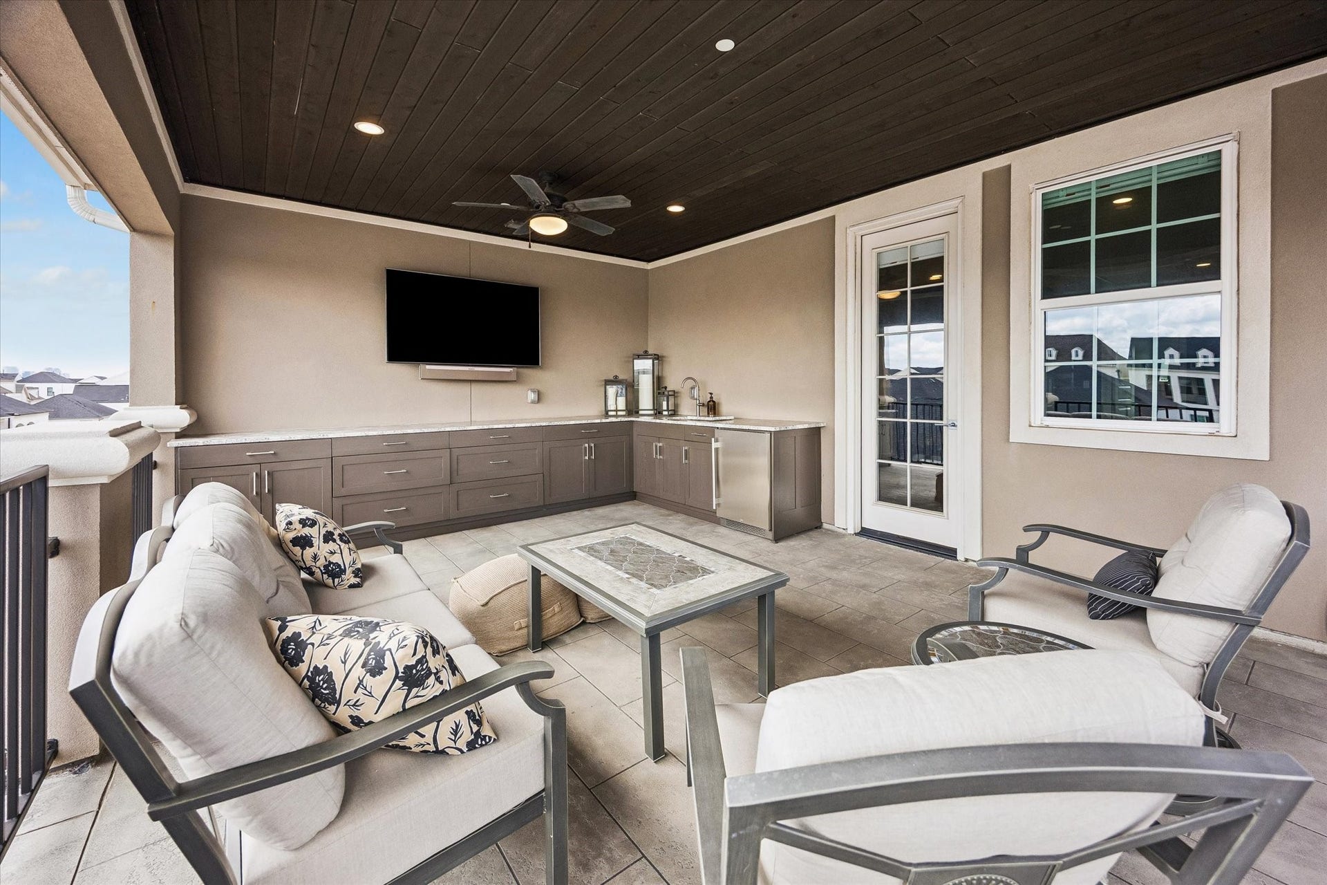 The expansive covered deck is a wonderful outdoor retreat equipped with a built-in wet bar and beverage refrigerator, providing a seamless environment for entertaining.