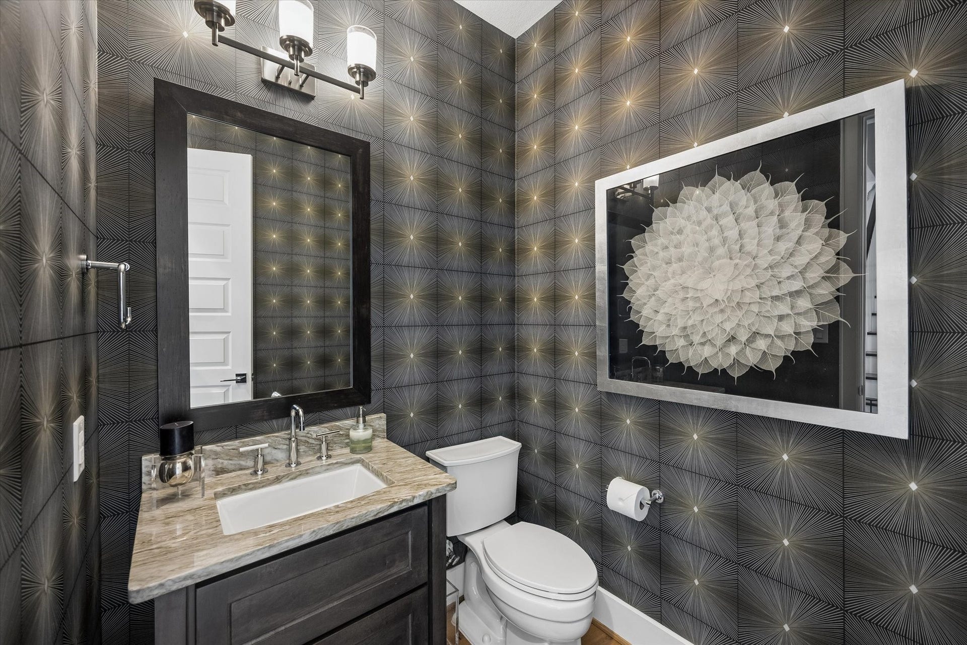 Perfectly positioned to serve the main living spaces, the powder room features custom wallpaper that introduces a sense of curated elegance found throughout the rest of the home.