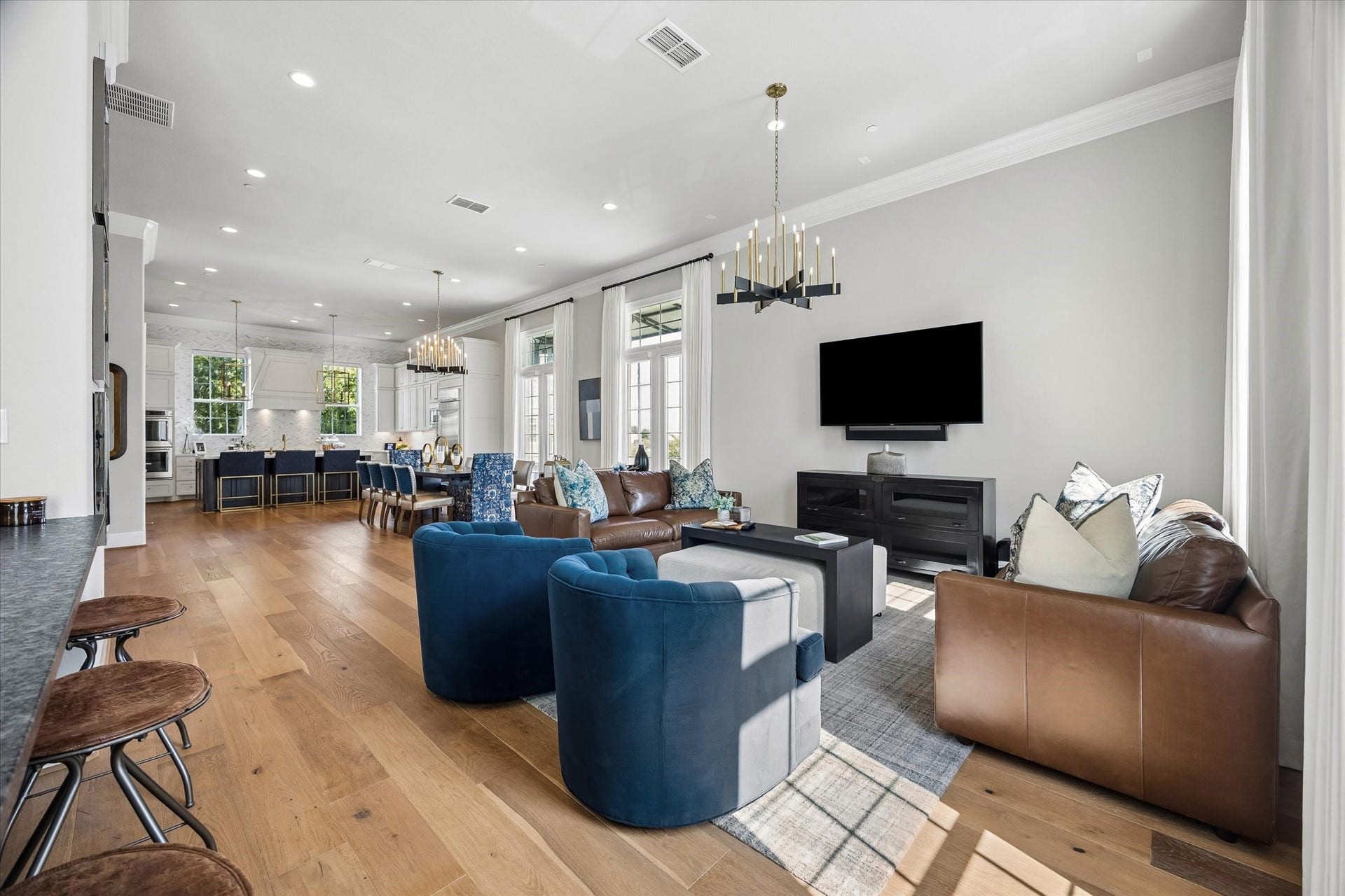 The main level features an expansive layout highlighted by rich wood floors, crown molding, and recessed lighting. Its a versatile space, finished with premium electric Hunter Douglas shades for effortless privacy and light control.