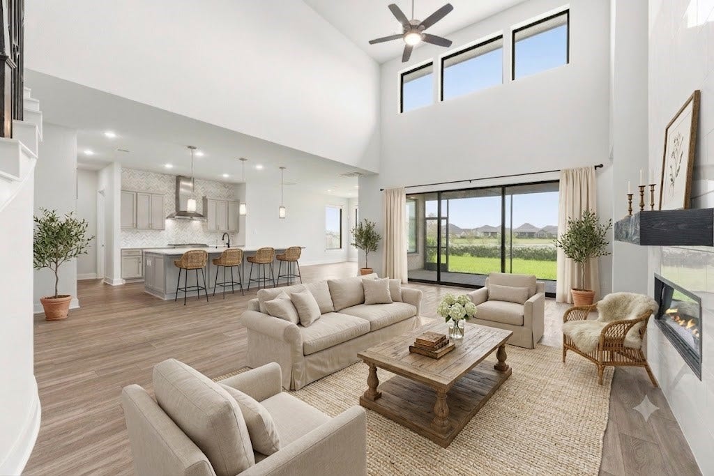 10314 Forest Lake Drive, Missouri City, TX 77459 Breathtaking open-concept living area featuring soaring two-story ceilings, wall of glass sliding doors to the patio, modern tile fireplace, and direct flow to the gourmet kitchen.