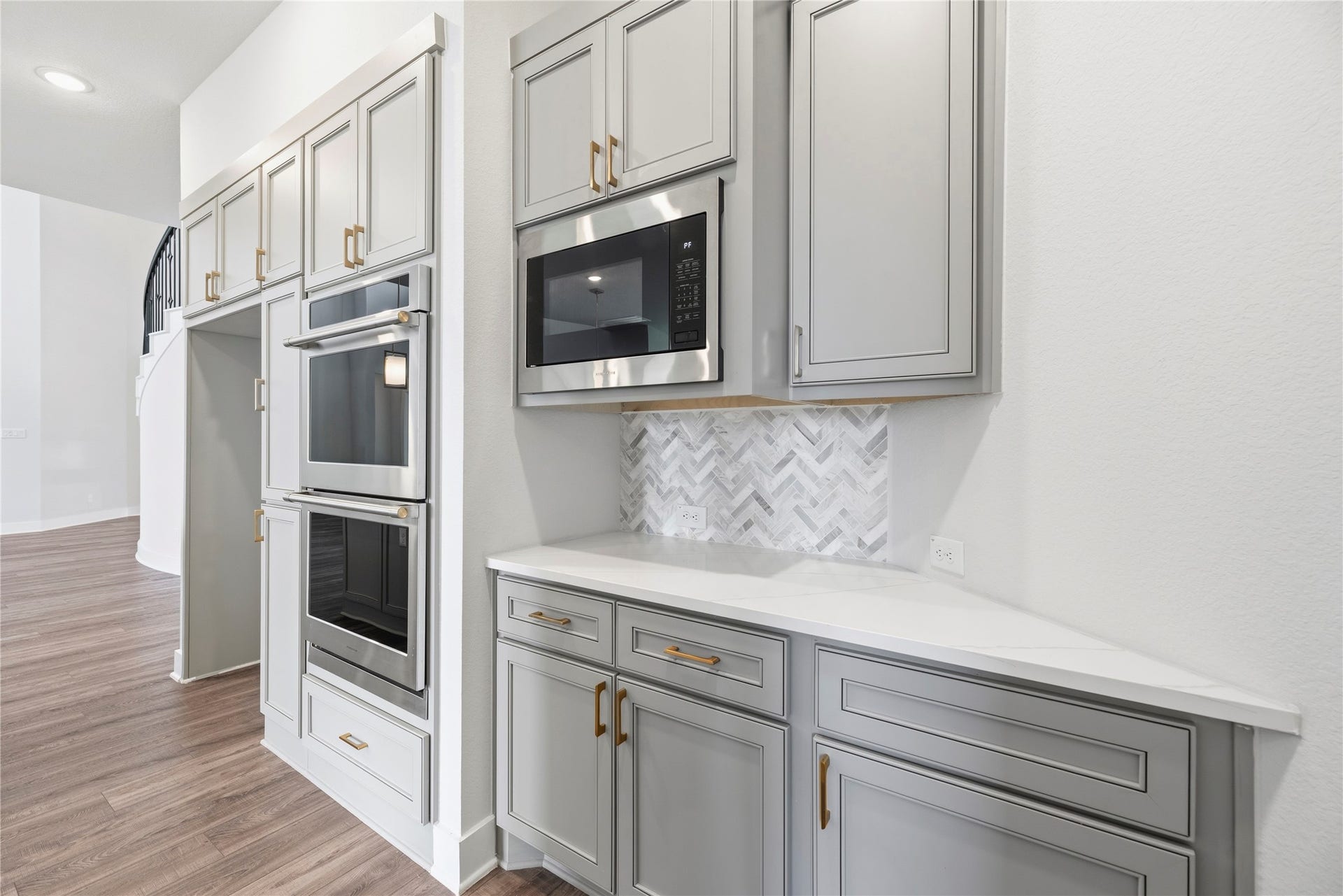 10314 Forest Lake Drive, Missouri City, TX 77459 Built-in wall feature complete with double wall ovens, separate built-in microwave, beverage/prep counter with matching herringbone backsplash, and upper storage cabinets.