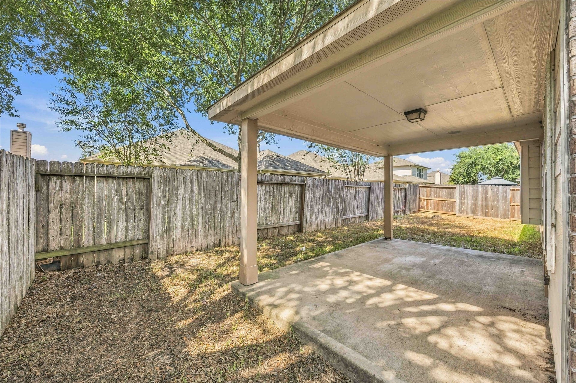 Covered back patio offers a shaded space to relax and enjoy the outdoors.