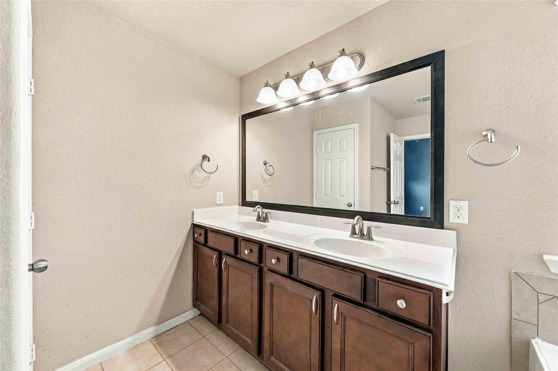 Primary bath features an extended vanity with ample storage.