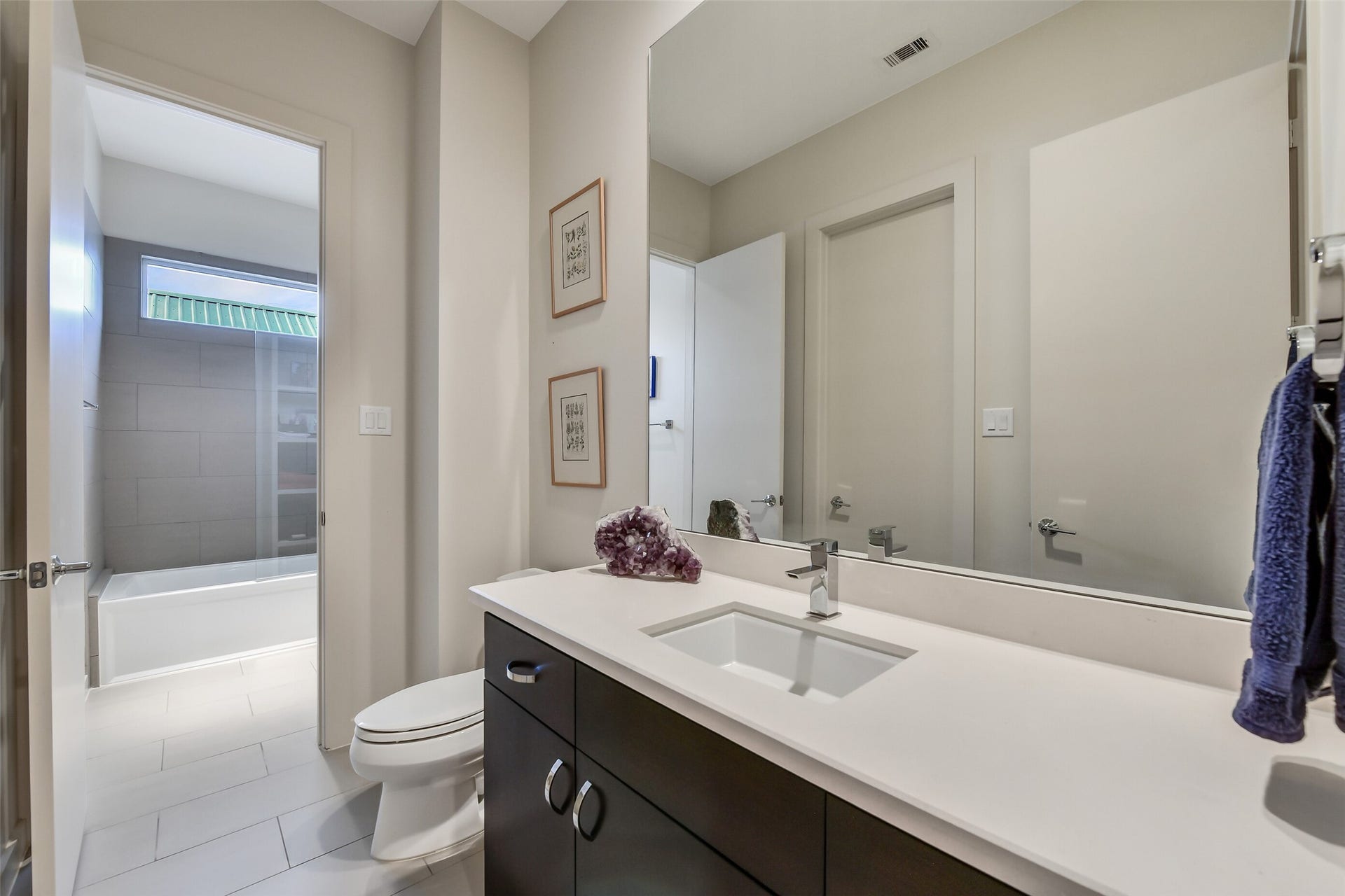 2302 Persa Street, Houston, TX 77019 Contemporary dark cabinetry contrasts beautifully with bright white quartz counter space and warm neutral walls
