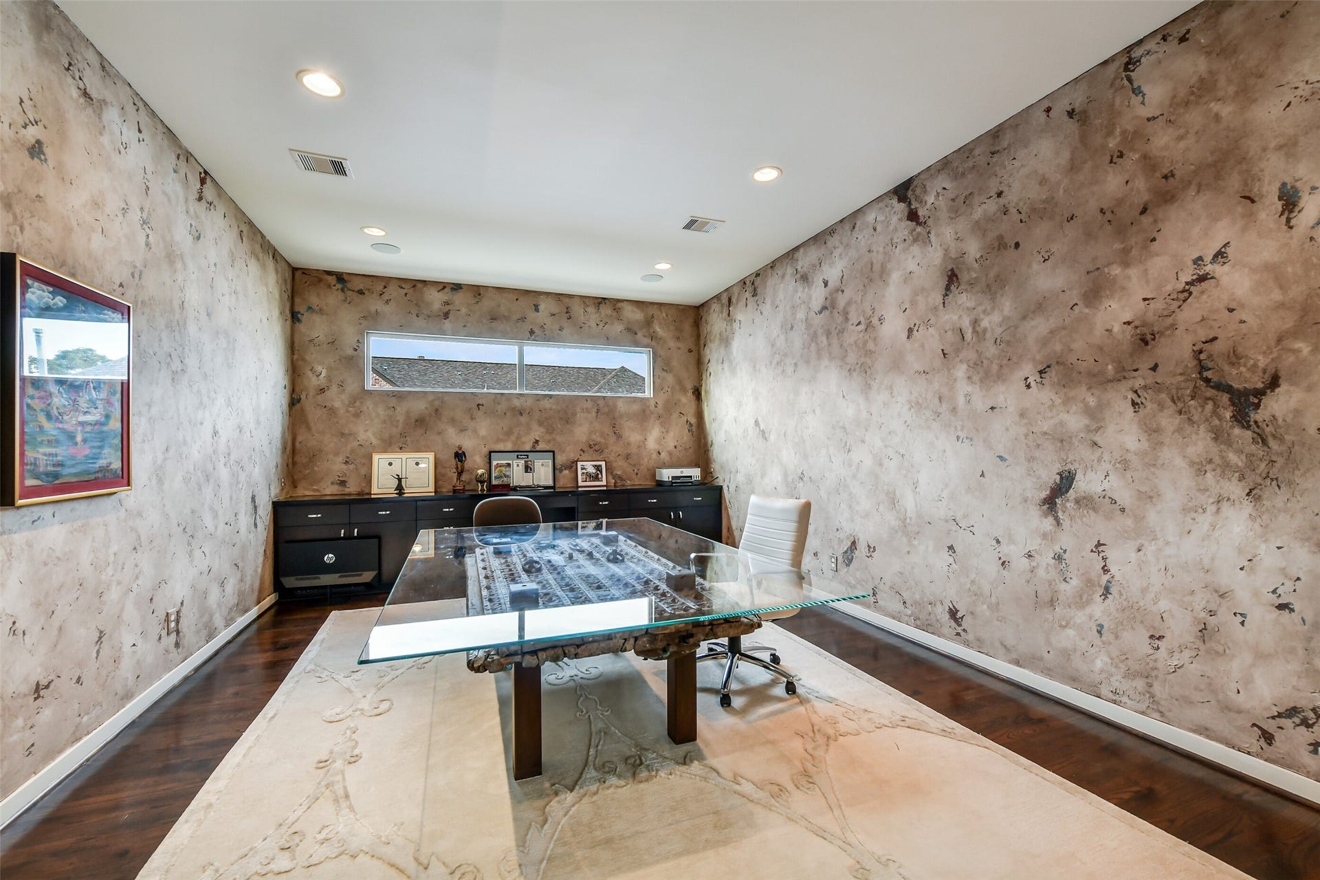 2302 Persa Street, Houston, TX 77019 This sophisticated multi-purpose space offers flexible living as a dedicated office, study, or flex room. Pocket doors provide sleek privacy, highlighting an expansive layout detailed with dark hardwood floors, dramatic faux-finish walls, recessed lighting, and built-in dark cabinetry for convenient storage.