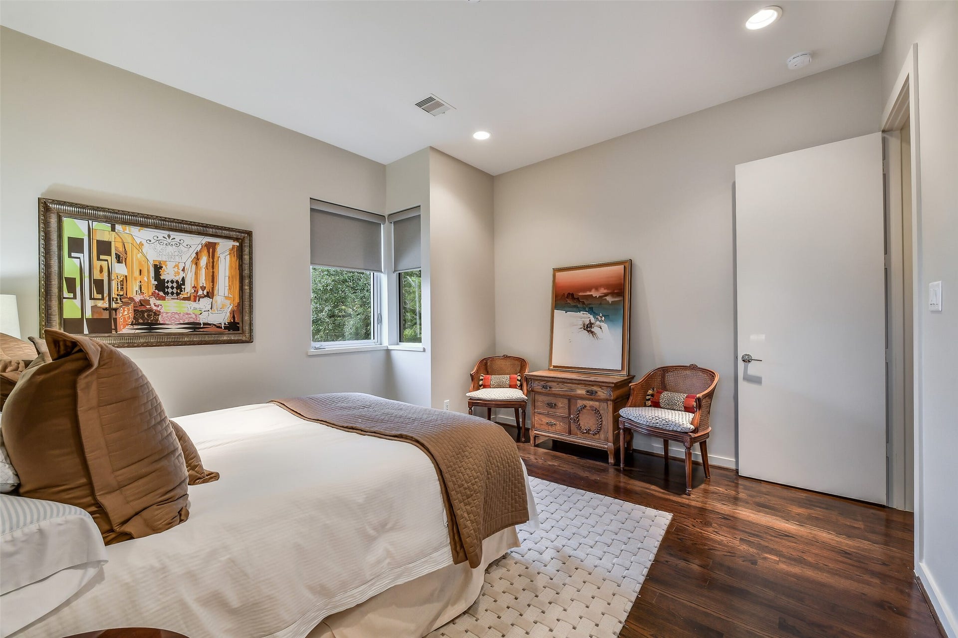 2302 Persa Street, Houston, TX 77019 Combining classic hardwood flooring with a serene color palette and double windows, this comfortable bedroom provides a functional and spacious design.
