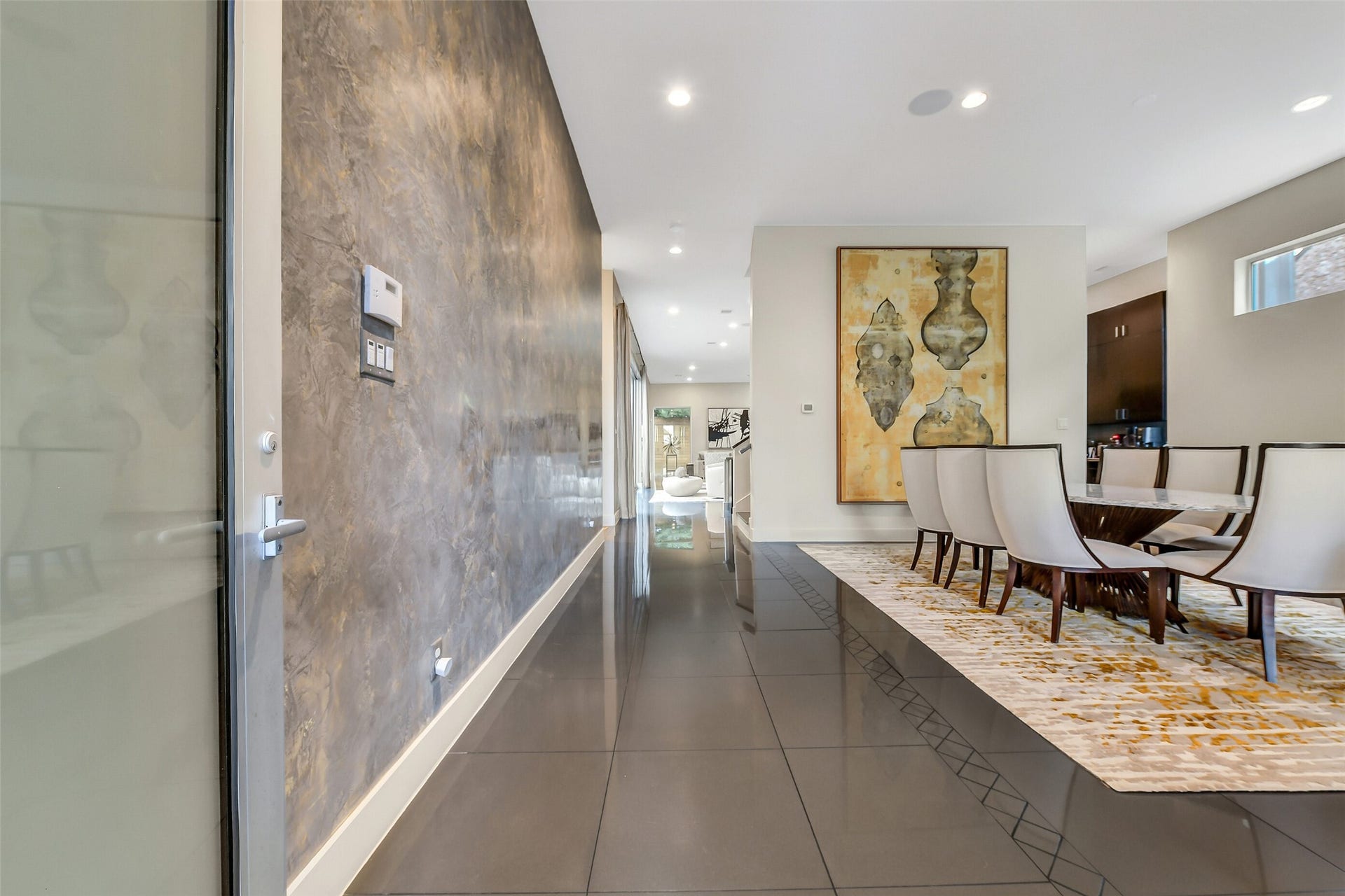 2302 Persa Street, Houston, TX 77019 This view captures the main enterance gallery, defined by sophisticated architectural textures and an open, light-filled progression into the formal living and dining spaces.