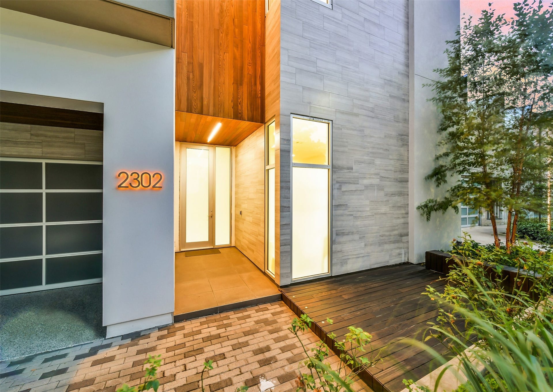 2302 Persa Street, Houston, TX 77019 The stunning architectural details highlight the front entrance, defined by rich textures and dramatic illumination. A sleek Italian marble facade seamlessly pairs with warm wood accents and oversized glass panels to create an unforgettable first impression.