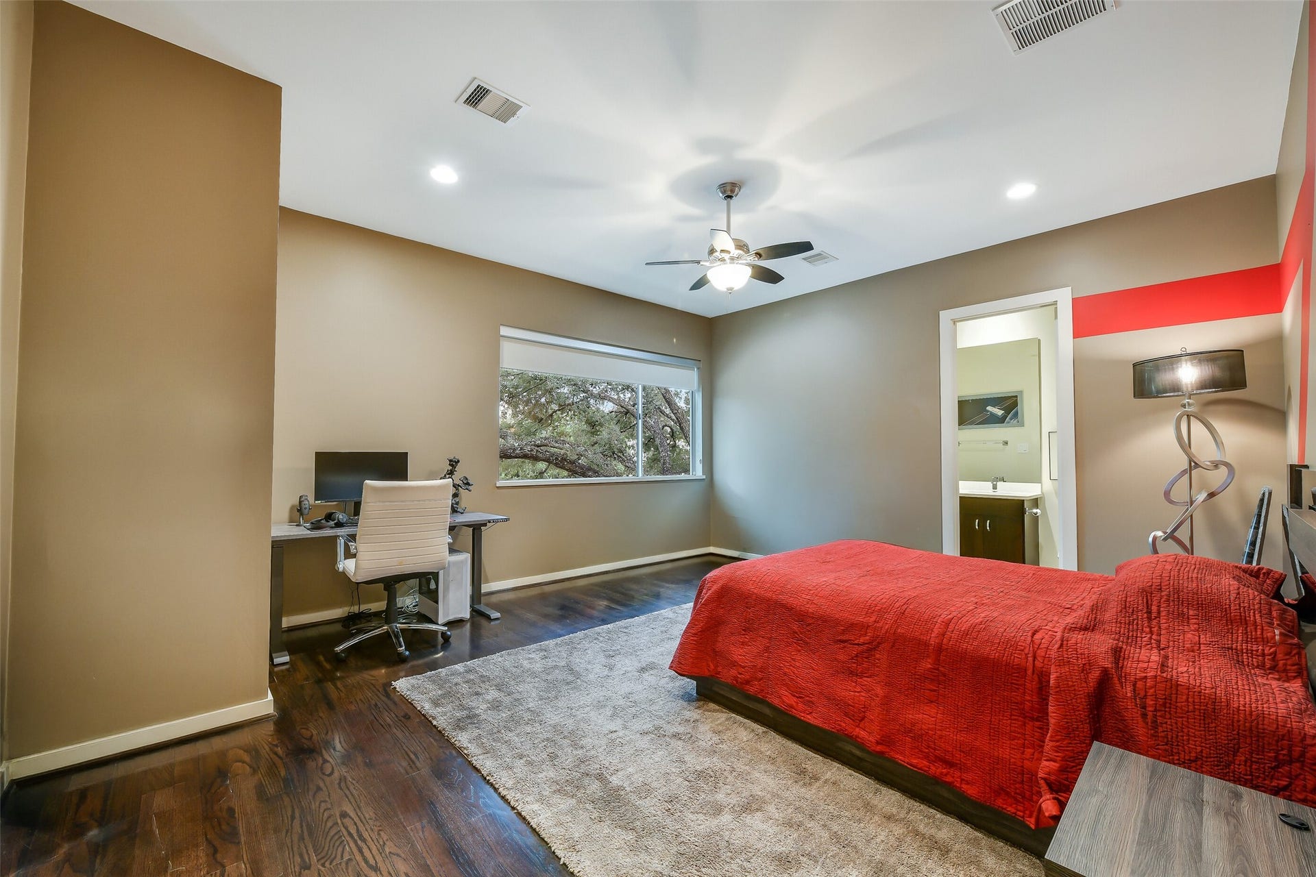 2302 Persa Street, Houston, TX 77019 An oversized window frames lush views of a mature live oak tree while filling this spacious secondary suite with abundant natural light.