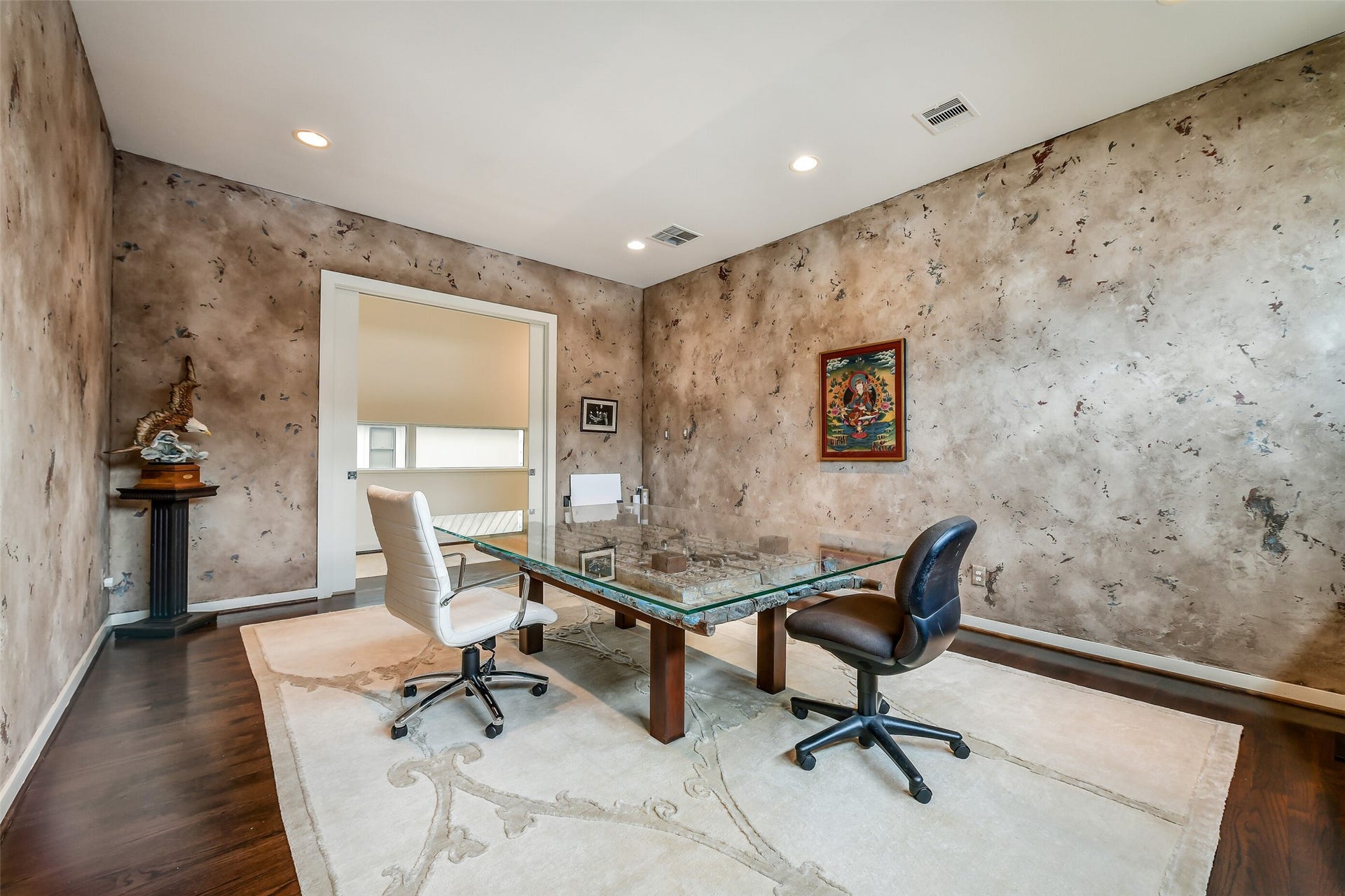 2302 Persa Street, Houston, TX 77019 Tucked behind sleek pocket doors, this spacious room features dark wood floors, distinctive textured walls, and flexible potential as an office or study.