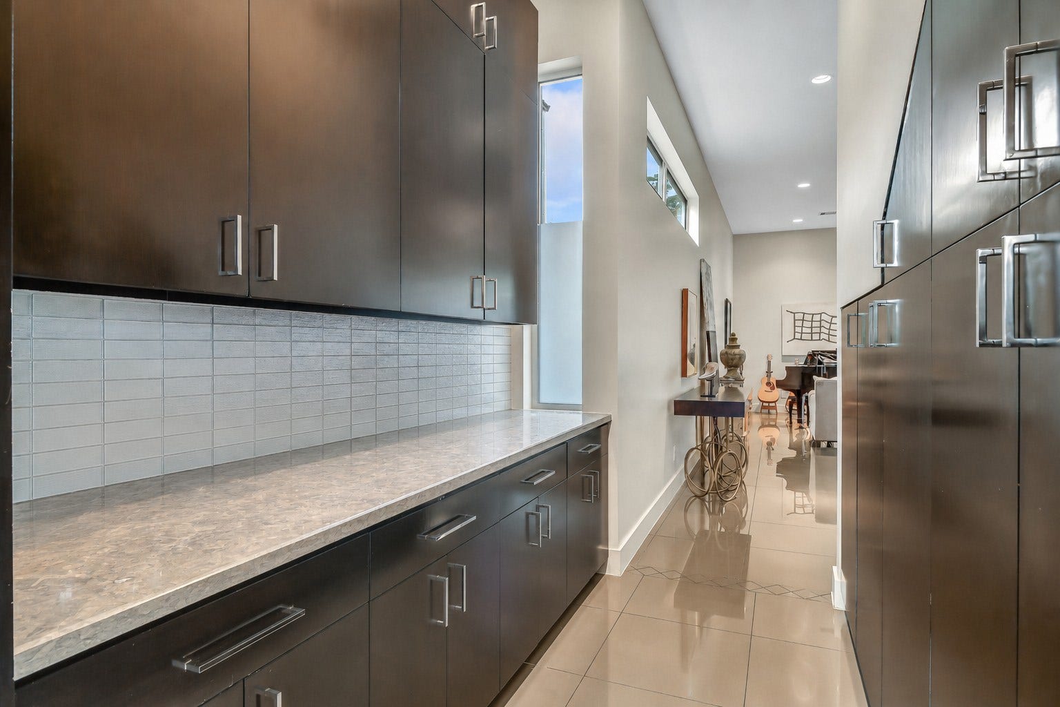 2302 Persa Street, Houston, TX 77019 The sophisticated butlers pantry creates an elegant bridge between the formal living and dining areas to the gourmet kitchen, serving as both a functional prep zone and a stylish design feature. Perfect for entertaining and provides ample storage for fine serveware.