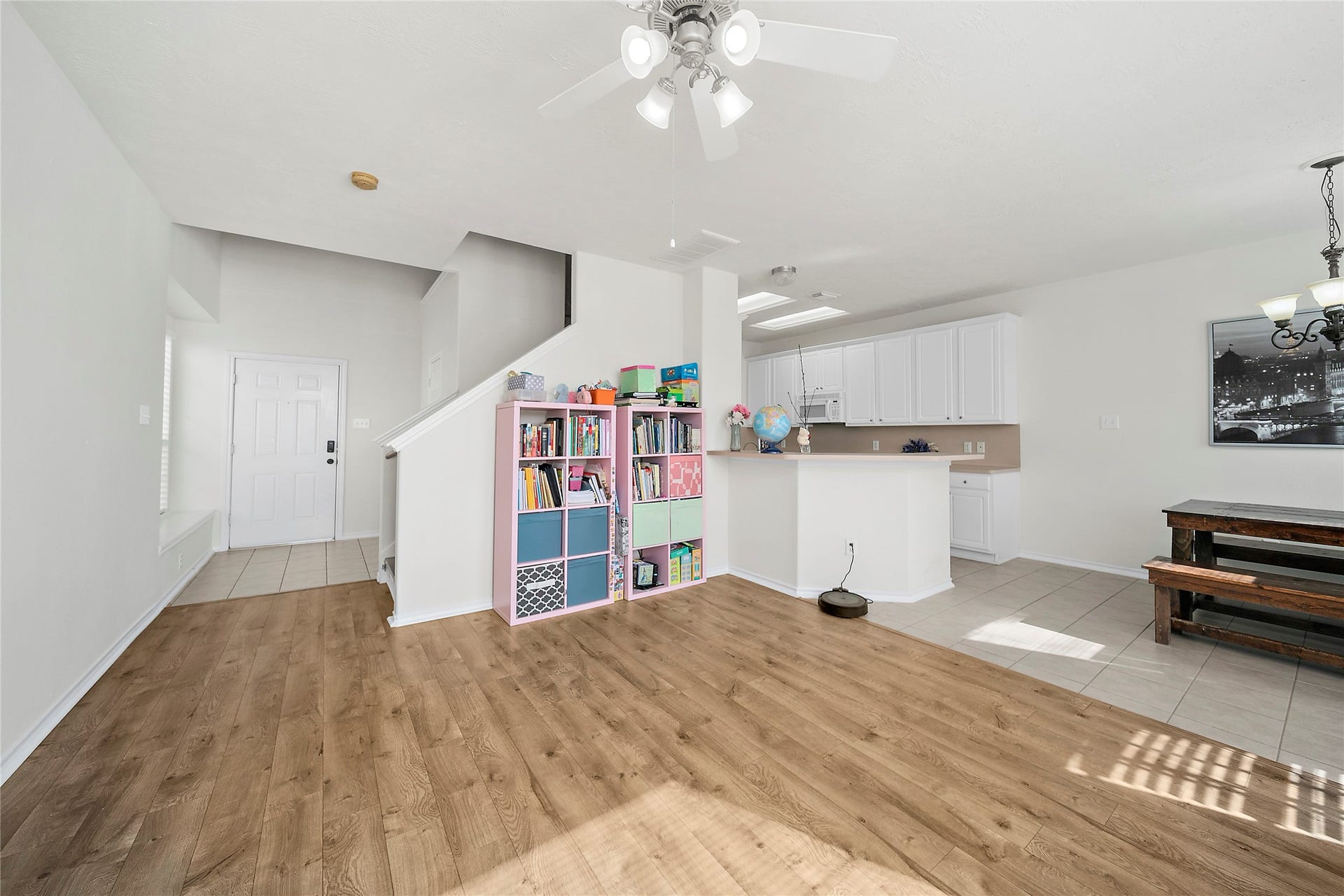 This is a two-story home with a beige exterior and a two-car garage. It features a small front yard with a walkway and some greenery. The house appears well-maintained and is part of a closely situated neighborhood.
