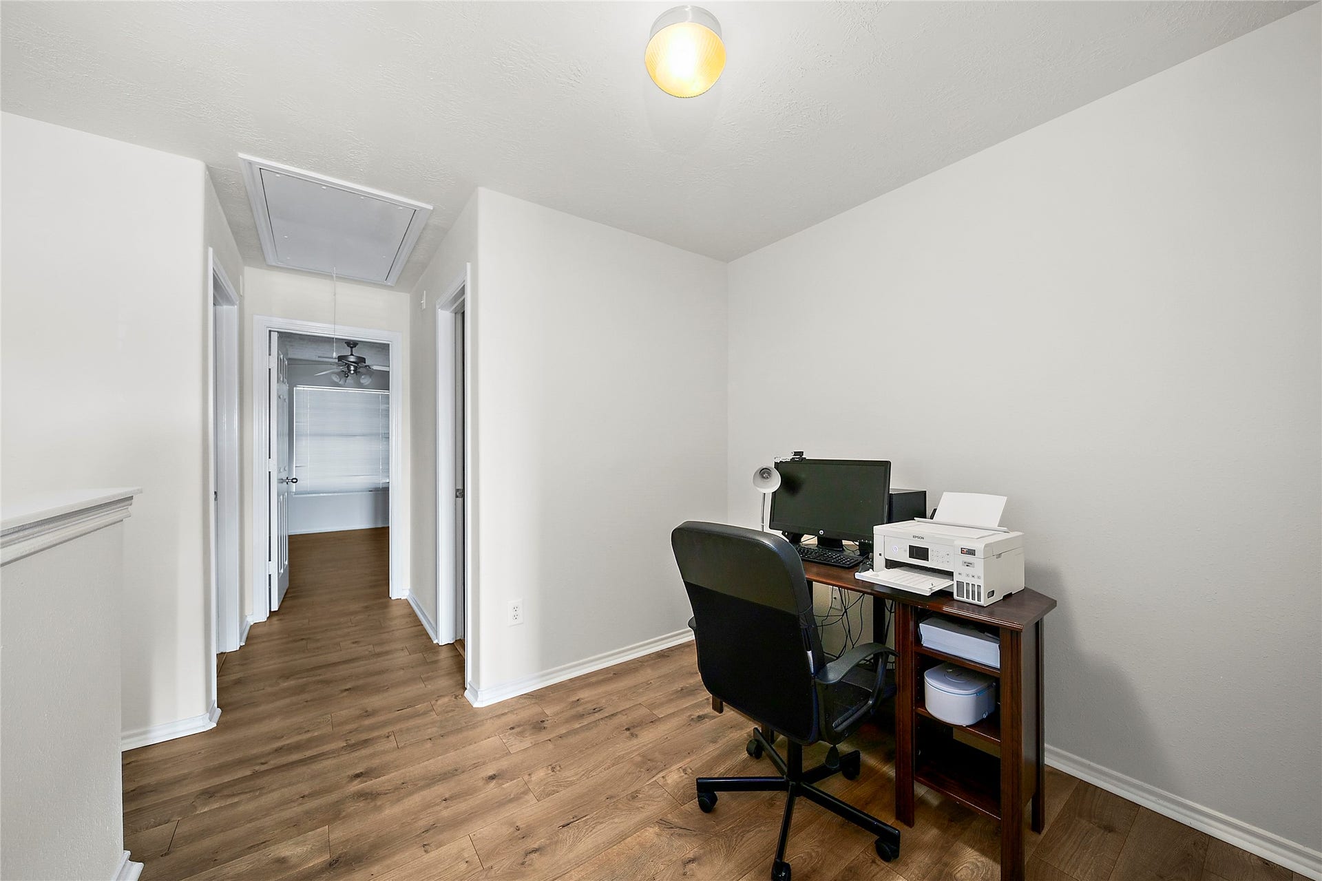 A functional office space with modern laminate flooring, perfect for productivity and focus.
