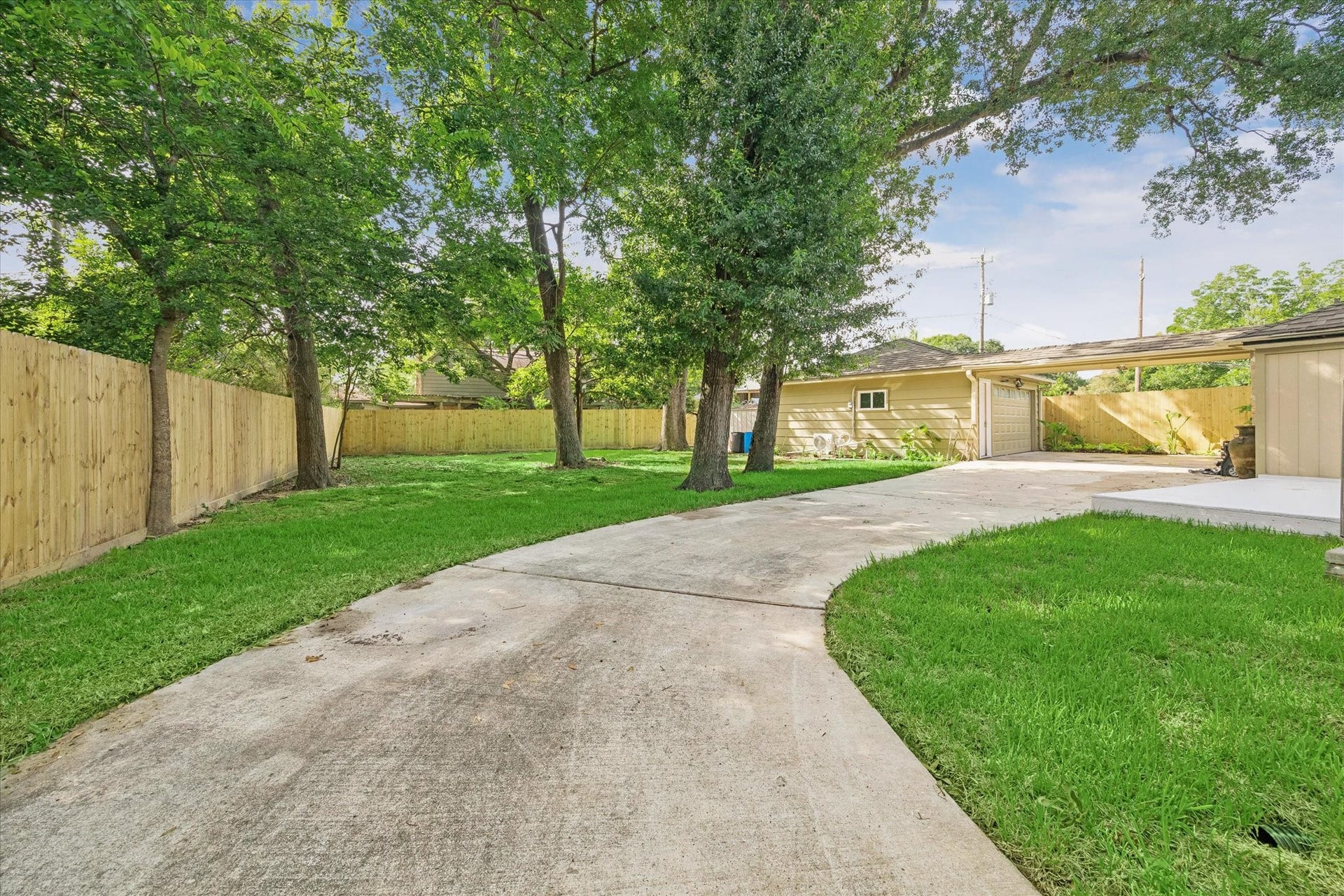 7827 Zilonis Court, Jersey Village, TX 77040 Driveway extends to the back for extra parking spaces and cement patio area for family BBQ.