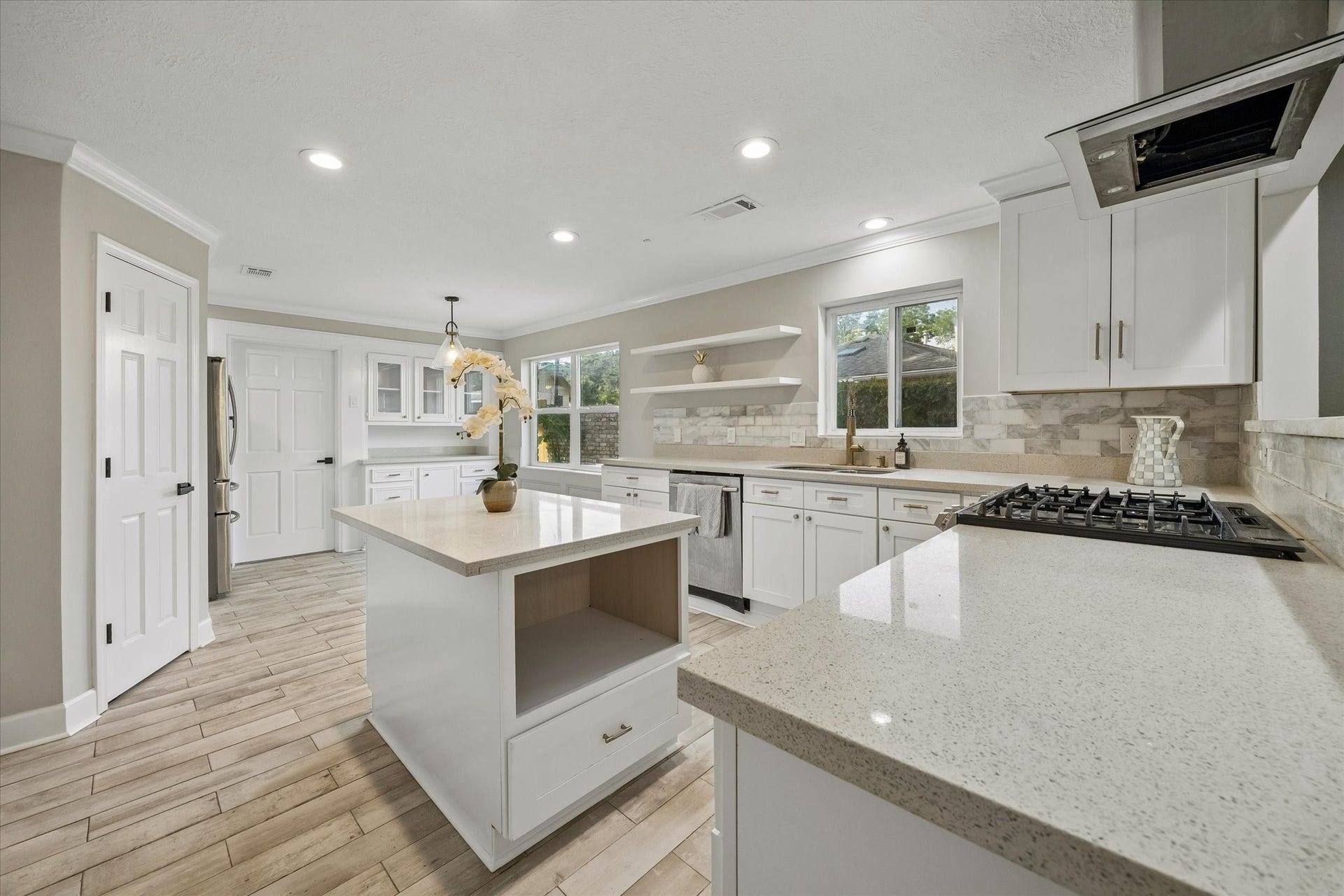 7827 Zilonis Court, Jersey Village, TX 77040 Modern kitchen featuring a sleek vent hood and high-performance gas stove.