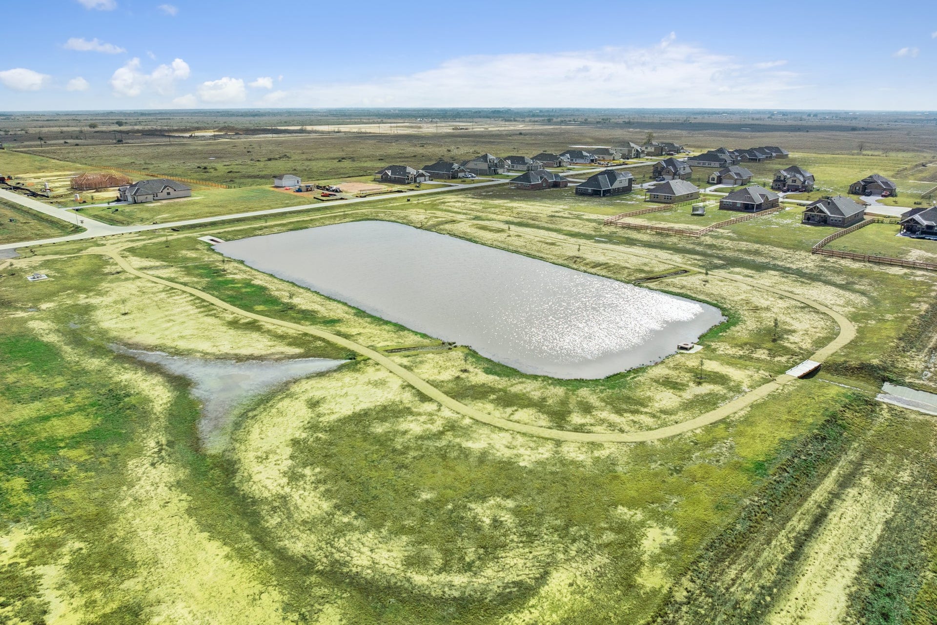 402 Cane Crossing Lake Drive, Sealy, TX 77474 The sparkling community pond provides a scenic centerpiece for the neighborhood, featuring walking trails perfect for your daily stroll or morning run