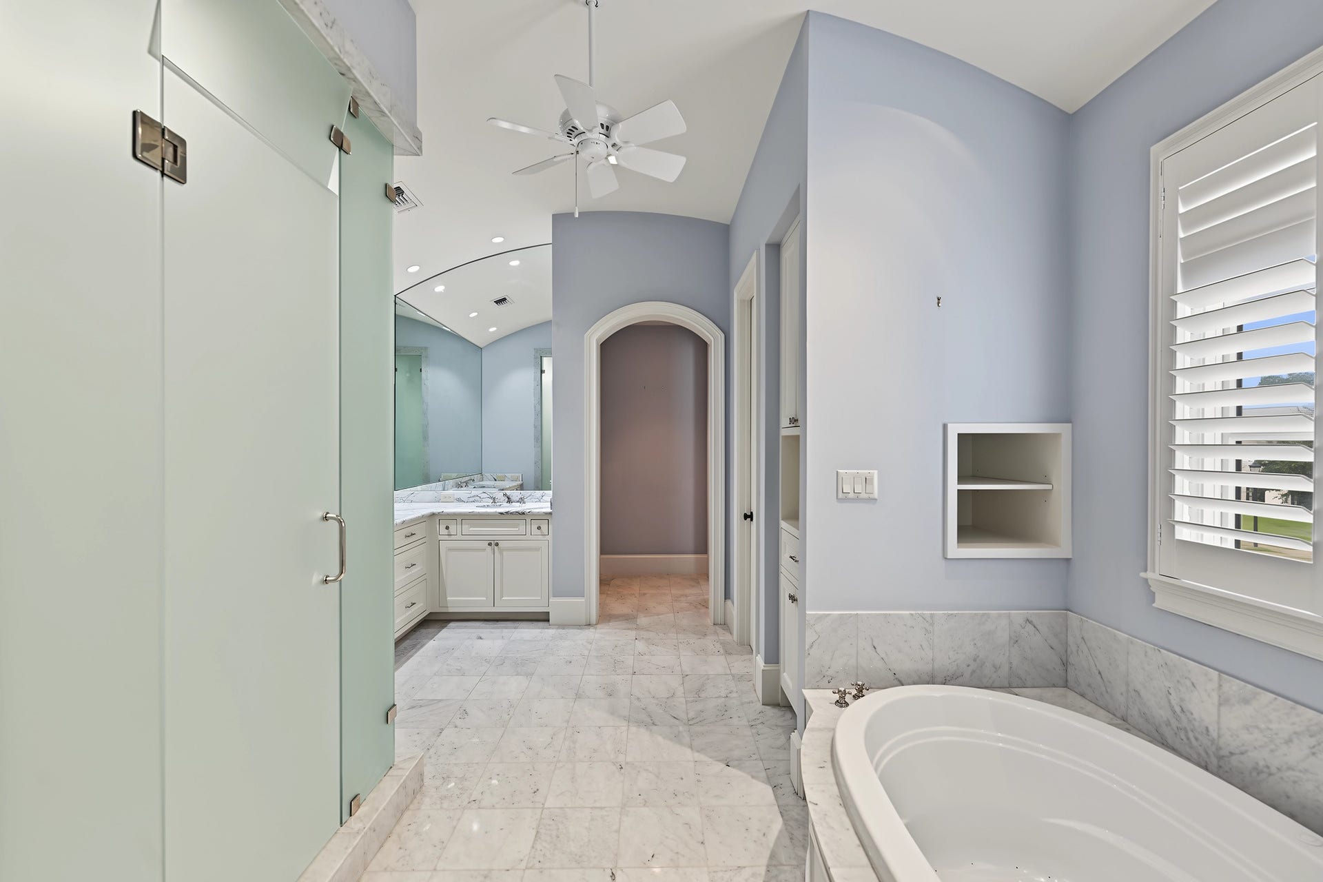 3223 Albans Road, West University Place, TX 77005 Spa-inspired primary bath offers a tranquil retreat with a soaking tub, spacious frosted-glass walk-in shower, built-in storage and timeless finishes.