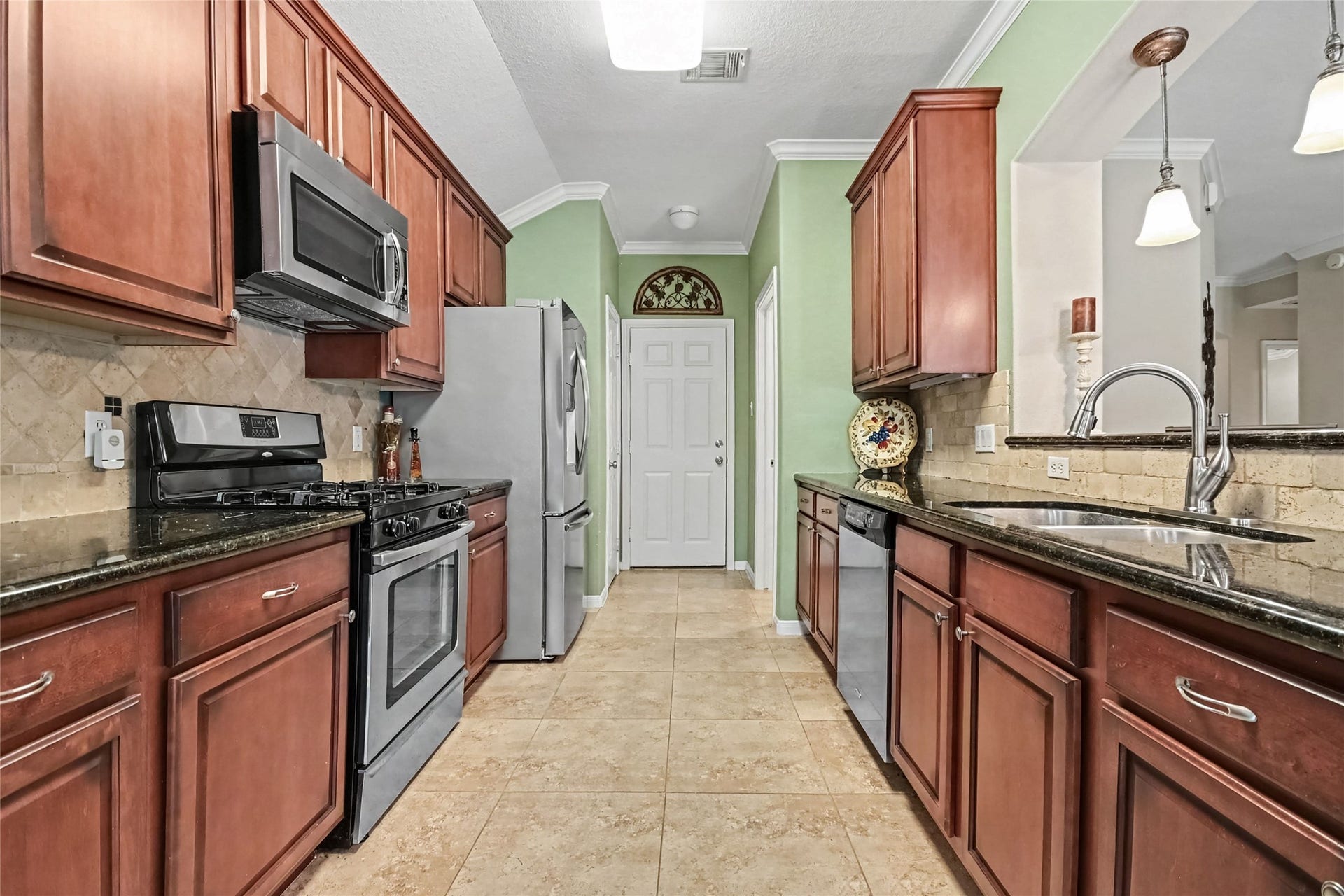 213 Rippling Creek Lane, Alvin, TX 77511 Spacious galley kitchen, featuring Gas cooking, granite countertops and custom cabinetry, oversized porcelain tile