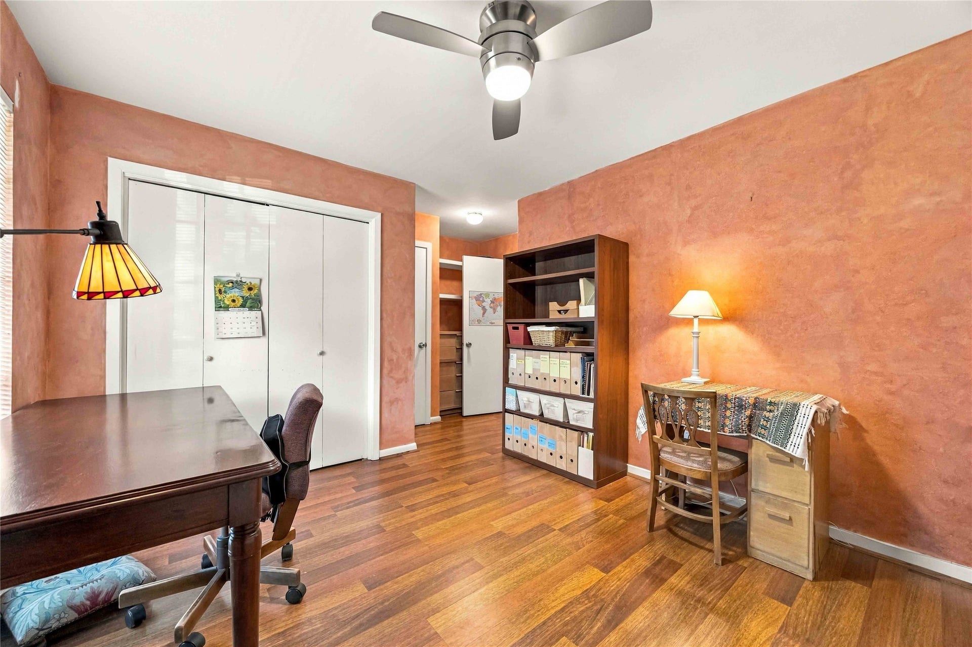 Versatile third bedroom with generous closet space and a ceiling fan, ideal for a bedroom, office, or flex space.