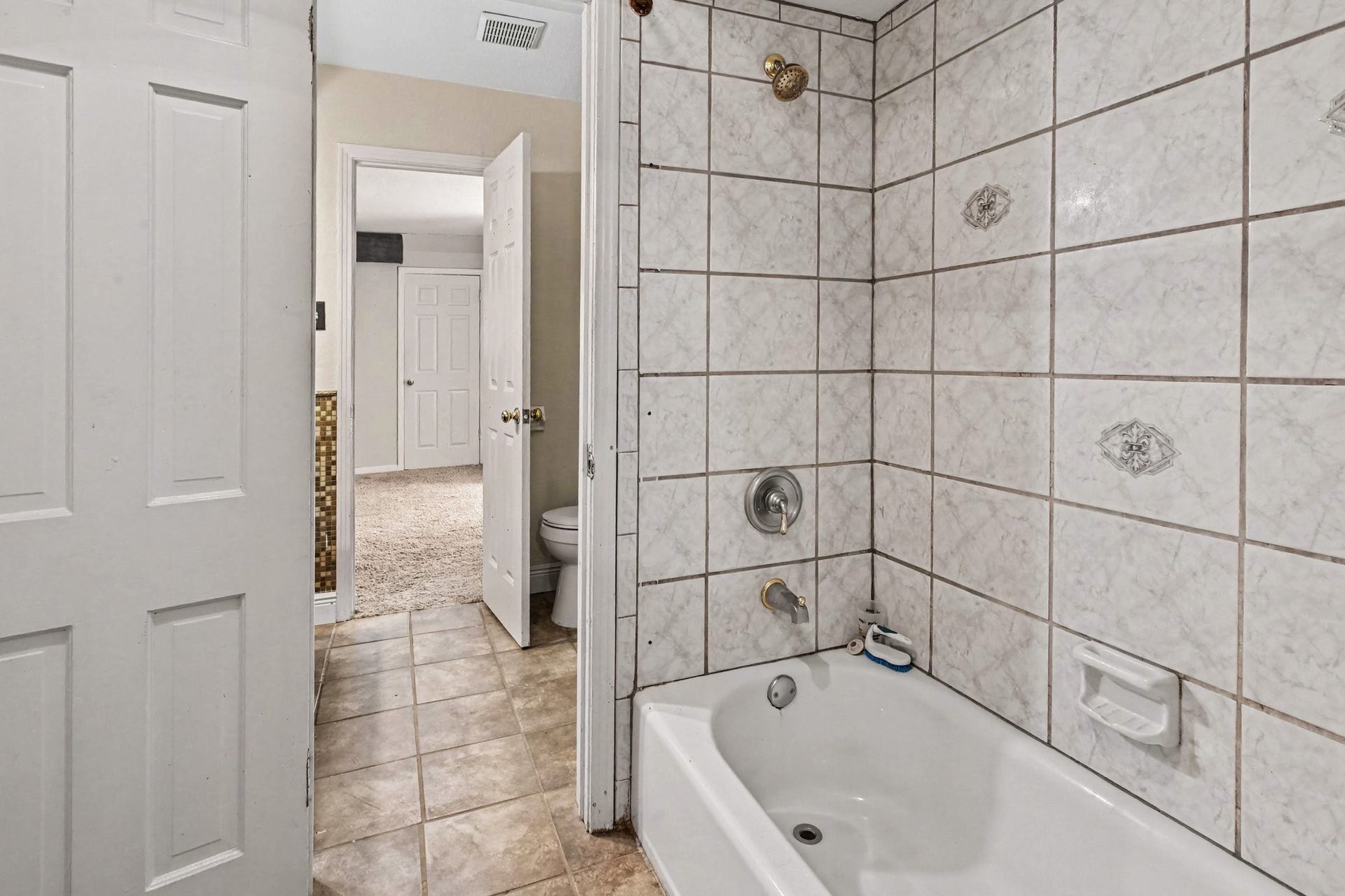 The shared shower/tub combo as part of the upstairs Jack and Jill bathroom