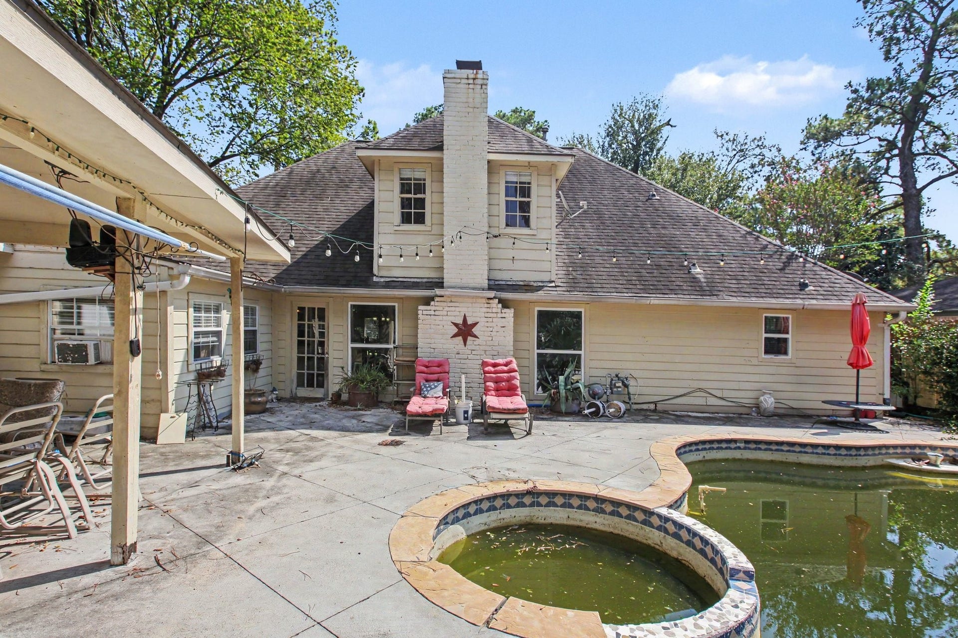 Mature palm trees, a covered patio, and the pool offer great potential