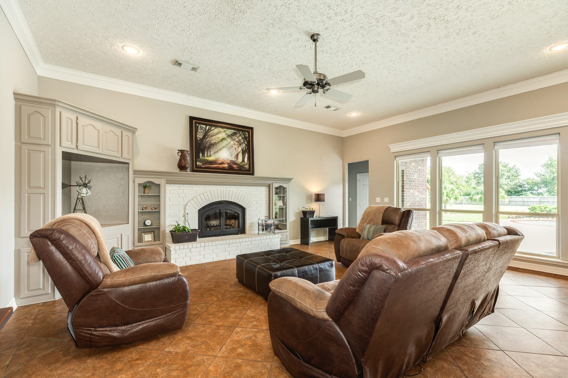 16337 County Road 171, Danbury, TX 77534 The second living area is anchored by a wood-burning fireplace featuring a Fireplace Xtrordinair heat distribution system, complemented by custom built-ins, high ceilings, and large windows overlooking the property.