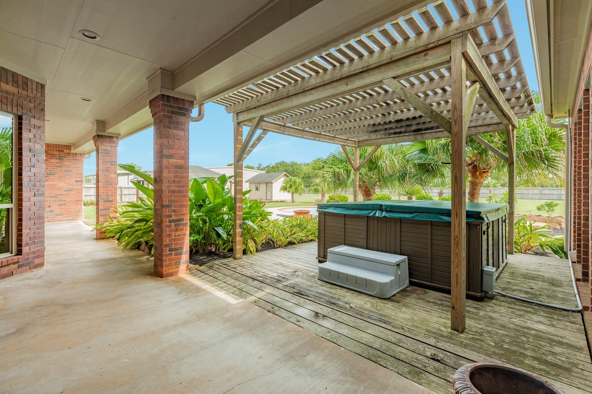 16337 County Road 171, Danbury, TX 77534 An 8-person hot tub sits beneath a charming pergola cover, creating a private outdoor retreat just steps from the home.