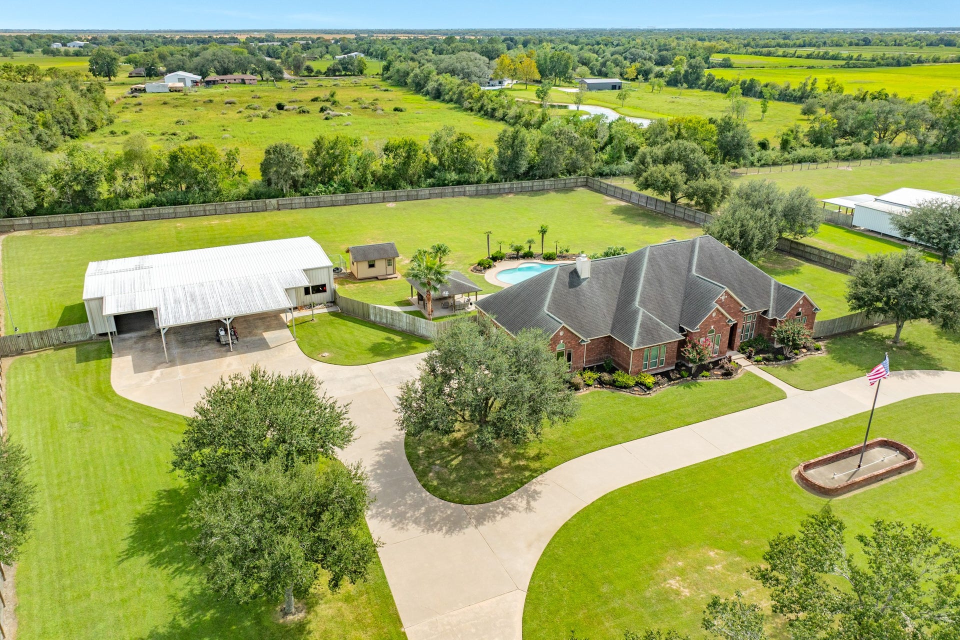 16337 County Road 171, Danbury, TX 77534 An aerial view showcases the property's impressive layout and extensive concrete parking, offering room to accommodate numerous vehicles with ease. The concrete has been professionally power washed every two years for continued upkeep.