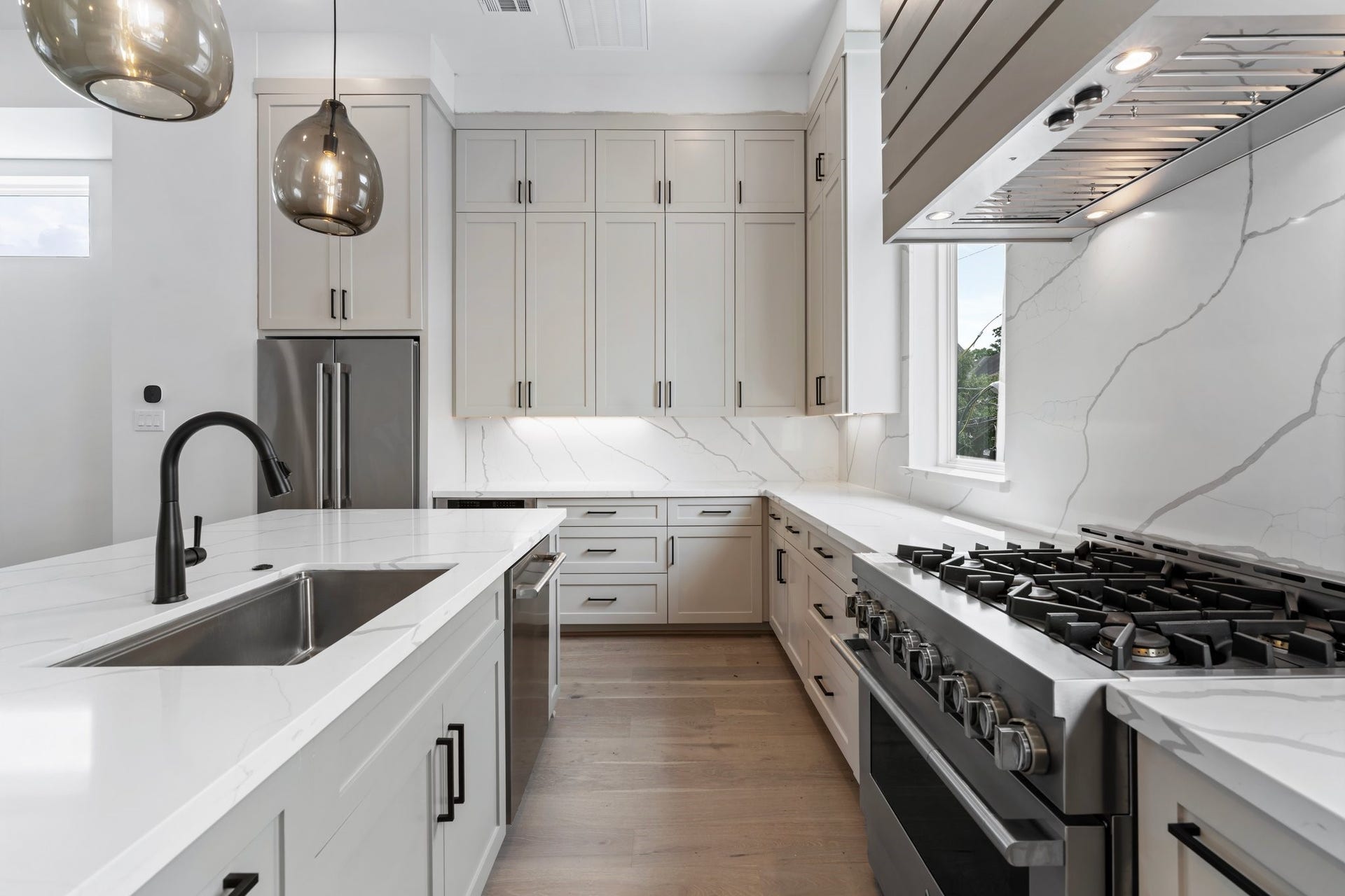 Closer up view of this dreamy kitchen.  Stainless steel JennAir appliance package includes: a large counter depth french door fridge/freezer, a 36 gas professional style range, an under counter microwave drawer and a dishwasher.